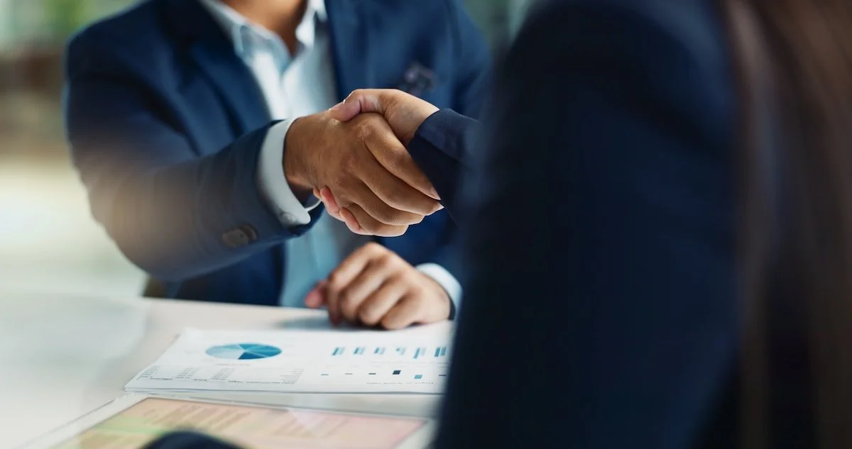 business professionals in suites shaking hands