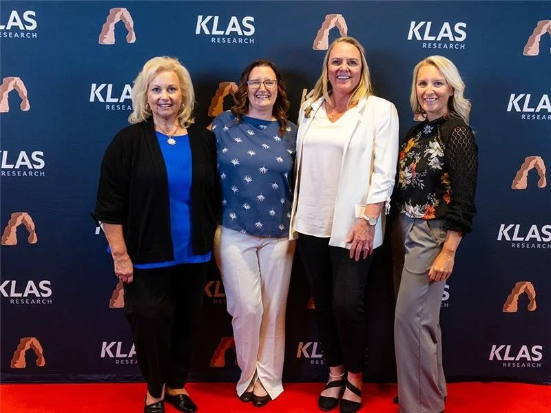 Four CSI team members standing on a red carpet at a KLAS research event.