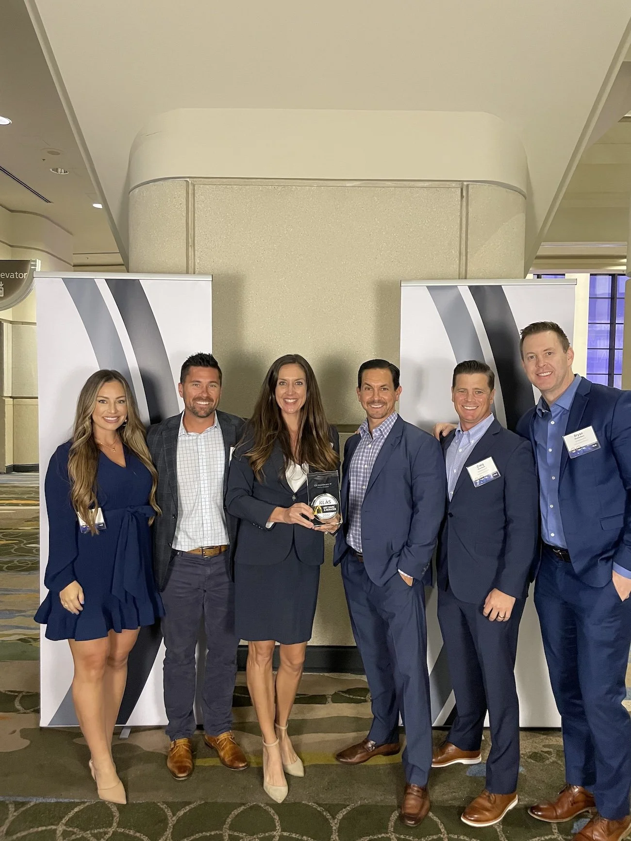 Group of six CSI leadership team members in formal attire standing together at a KLAS award ceremony.