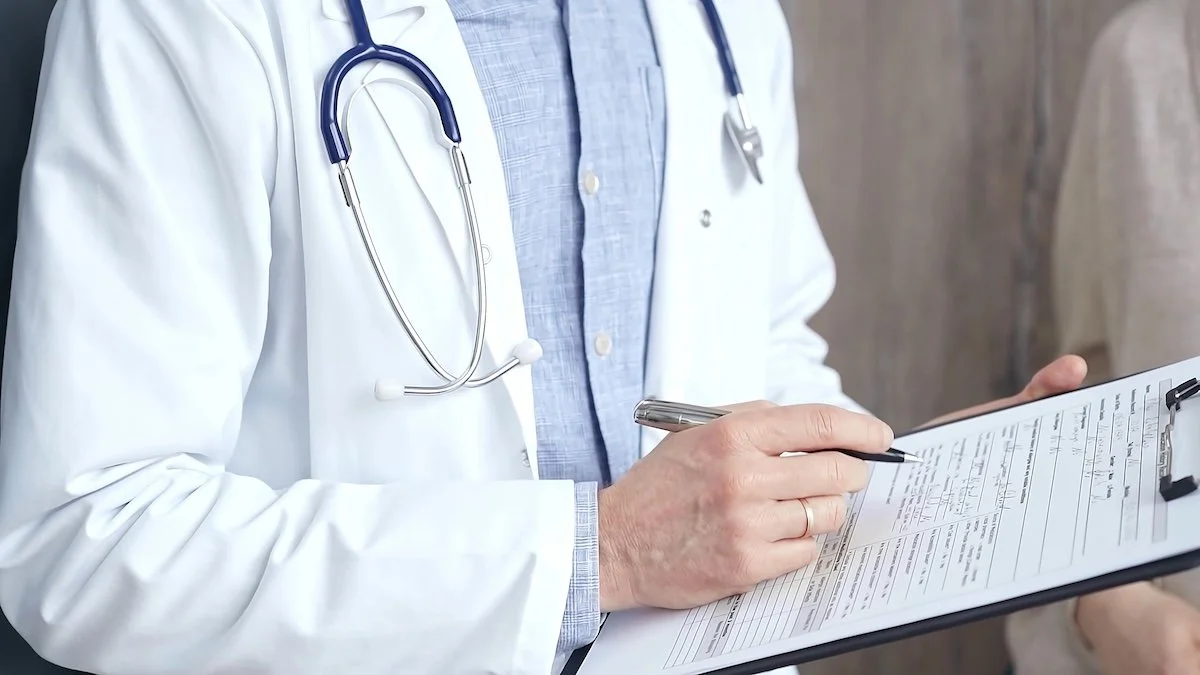 Doctor with stethoscope reviewing charts, assessing clinical documentation