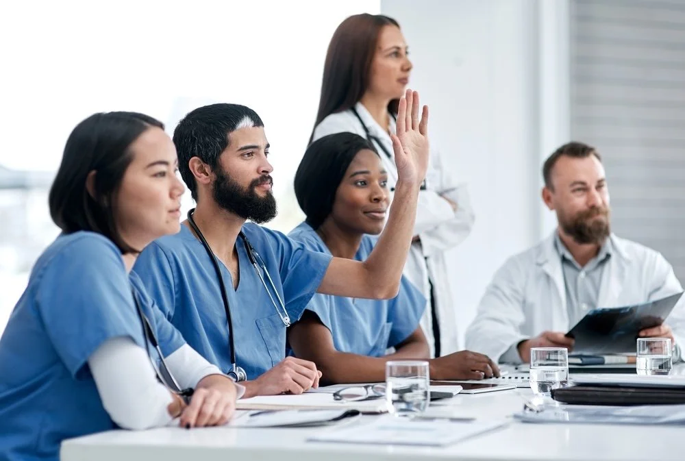 Medical team in a meeting, engaged in classroom training session.