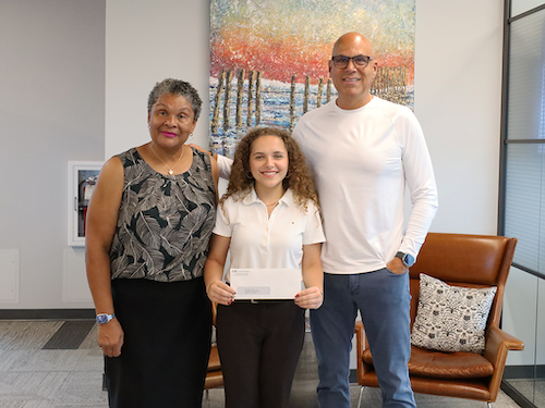 Two CSI leadership team member and a young girl who previously won the Guy Cuddiee's scholarship standing posing for a photo.