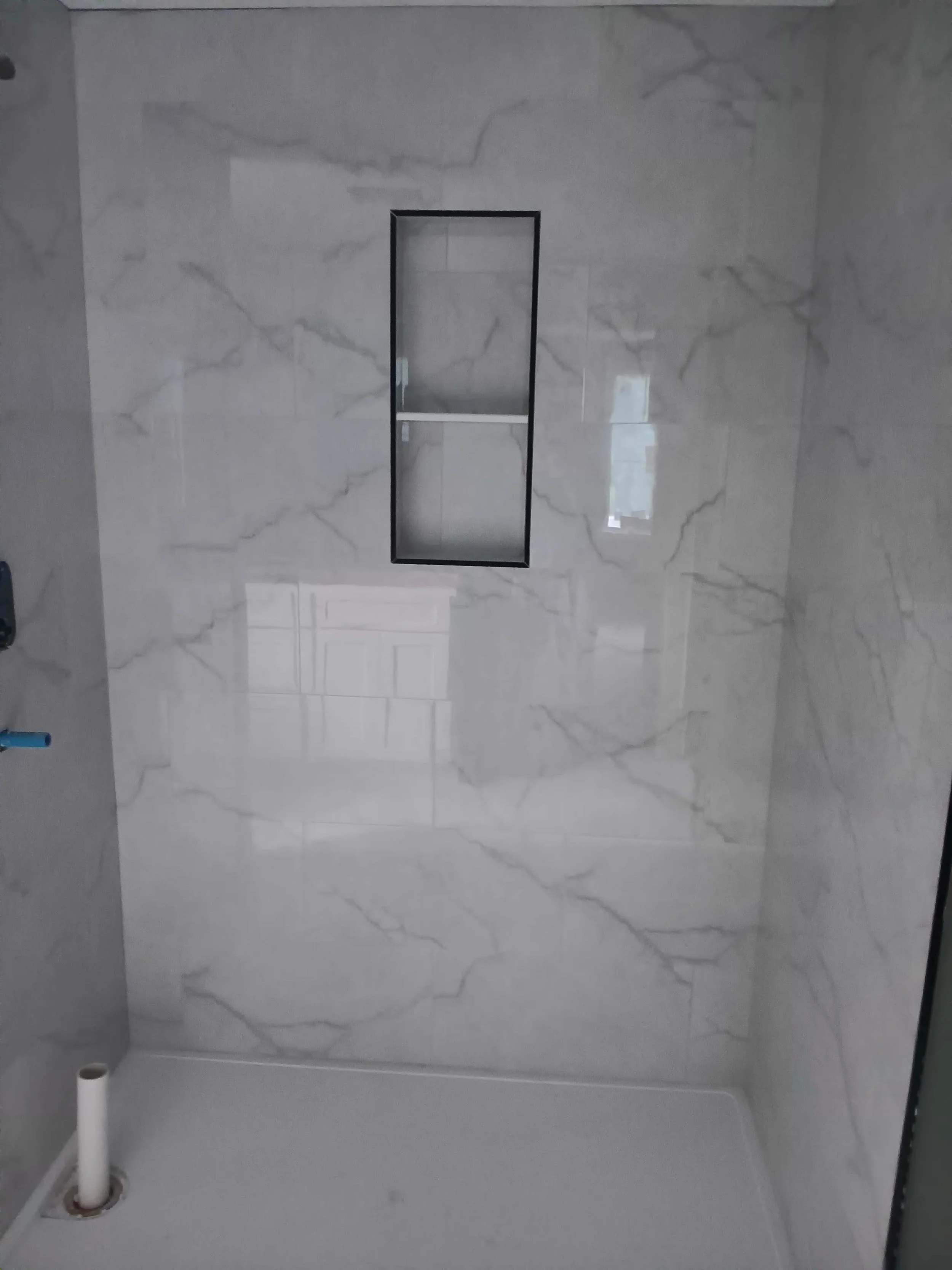 Bathroom with wall tiles, a built-in shower niche