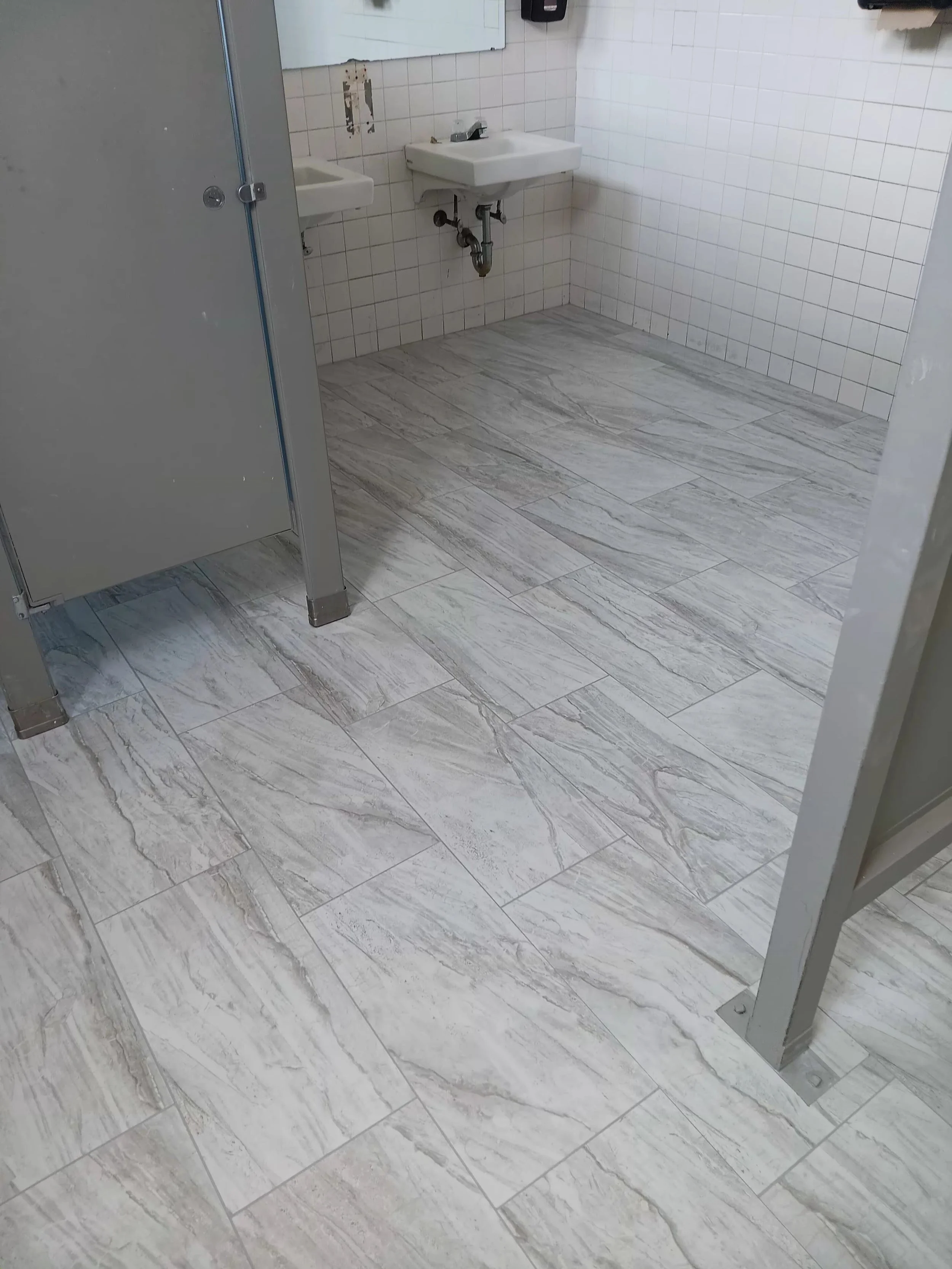 Public bathroom with beige marble floor tiles