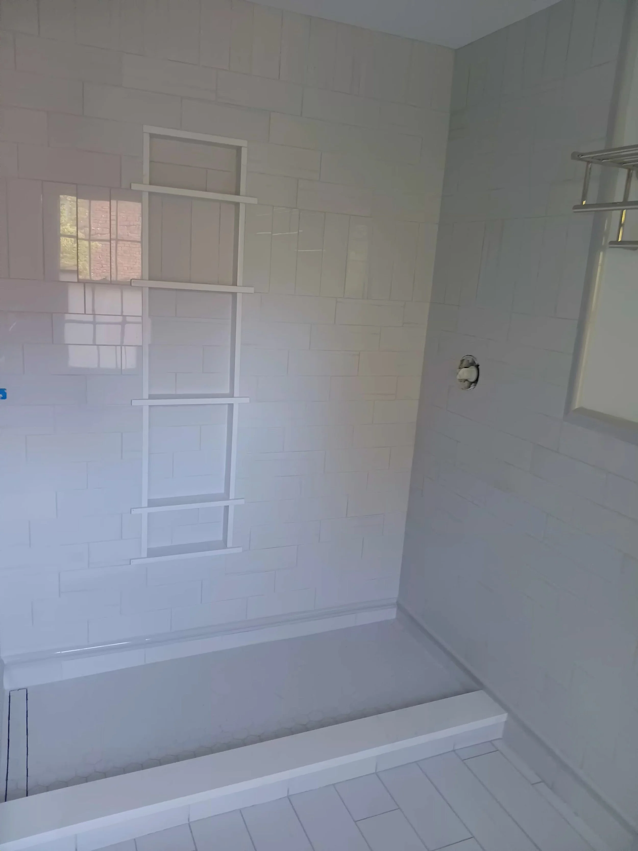A bathroom with white tiled walls and floor