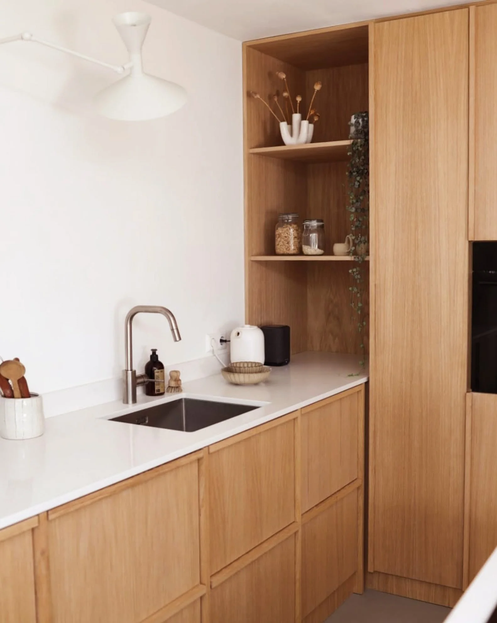 Cuisine en chêne sur mesure réalisée par Atelier Set, avec façades en bois naturel et poignées longues en laiton