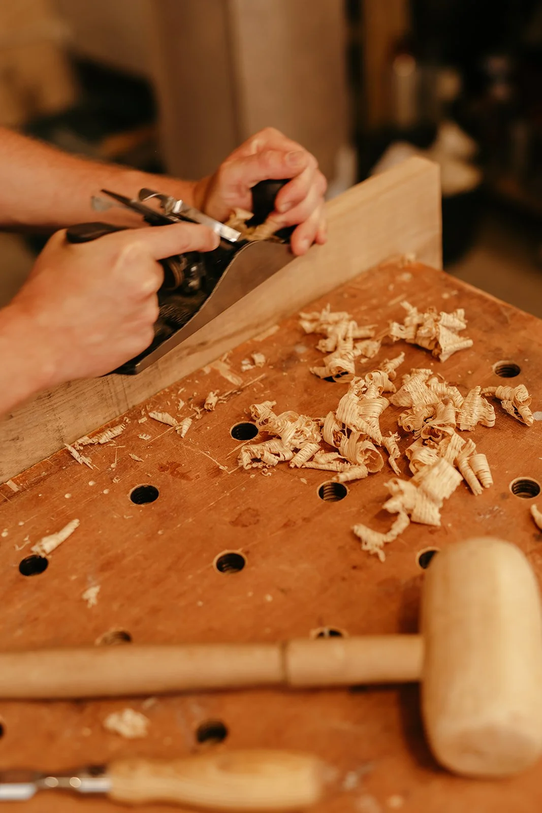 Détail du travail du bois au rabot à main dans l'atelier de menuiserie Atelier Set