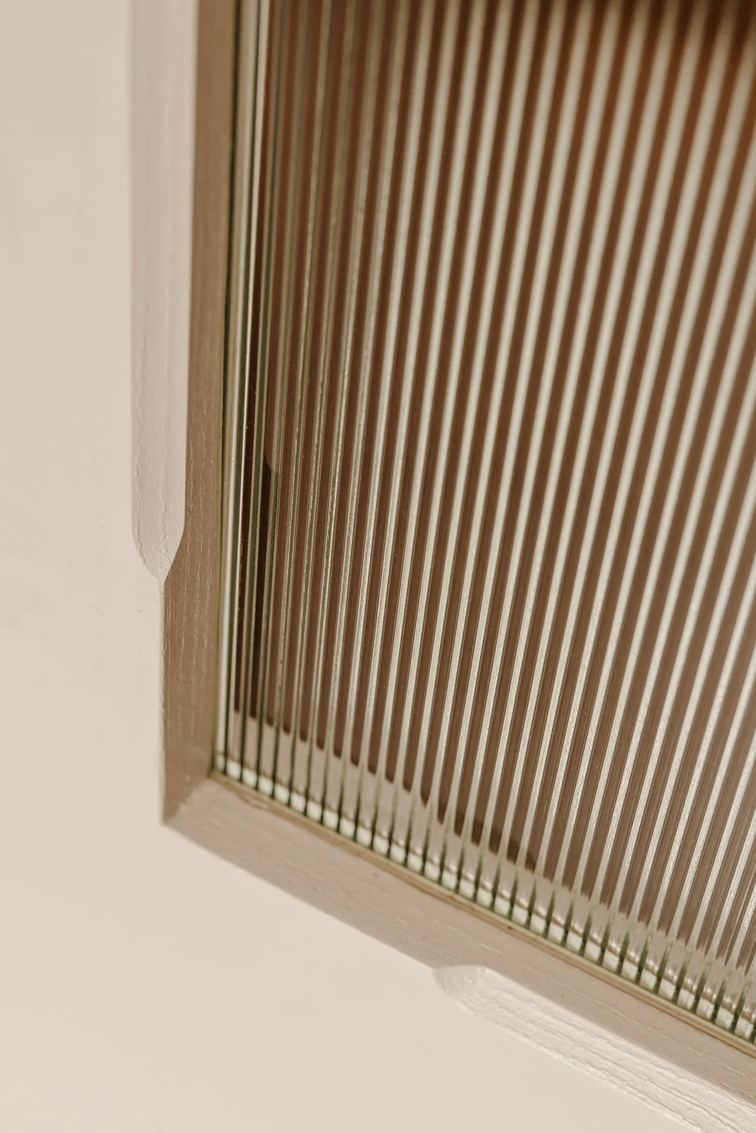 Détail d'une porte en chêne avec vitrage strié et finitions soignées