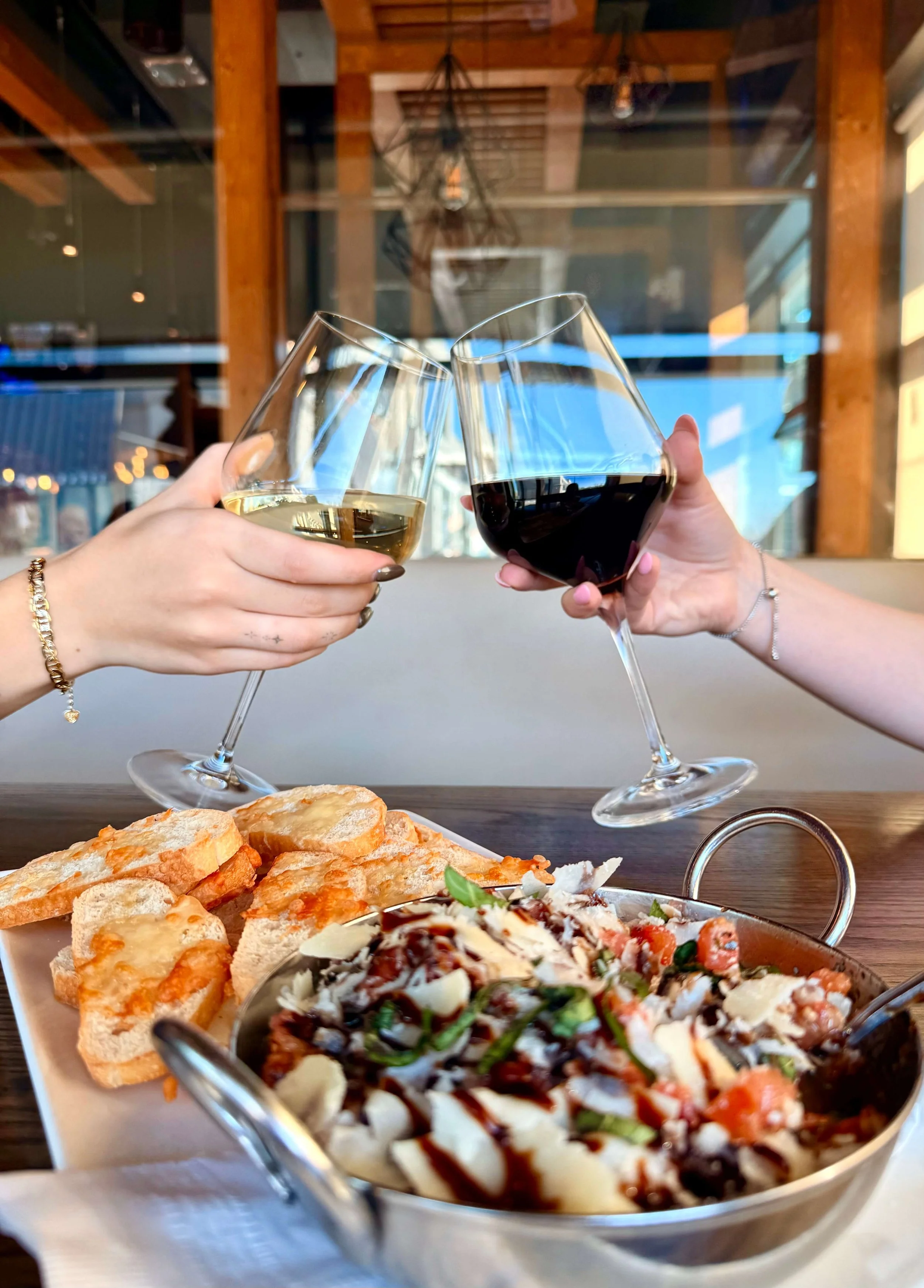 Two wine glasses cheers, with appetizer