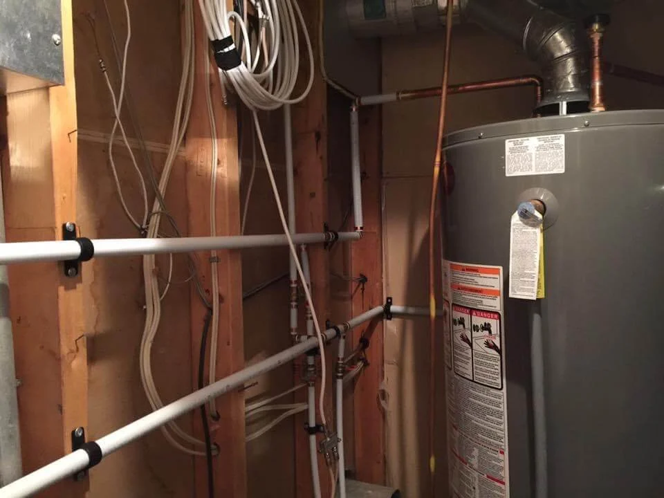 Newly installed high-efficiency hot water tank with professional copper piping and shut-off valves.
