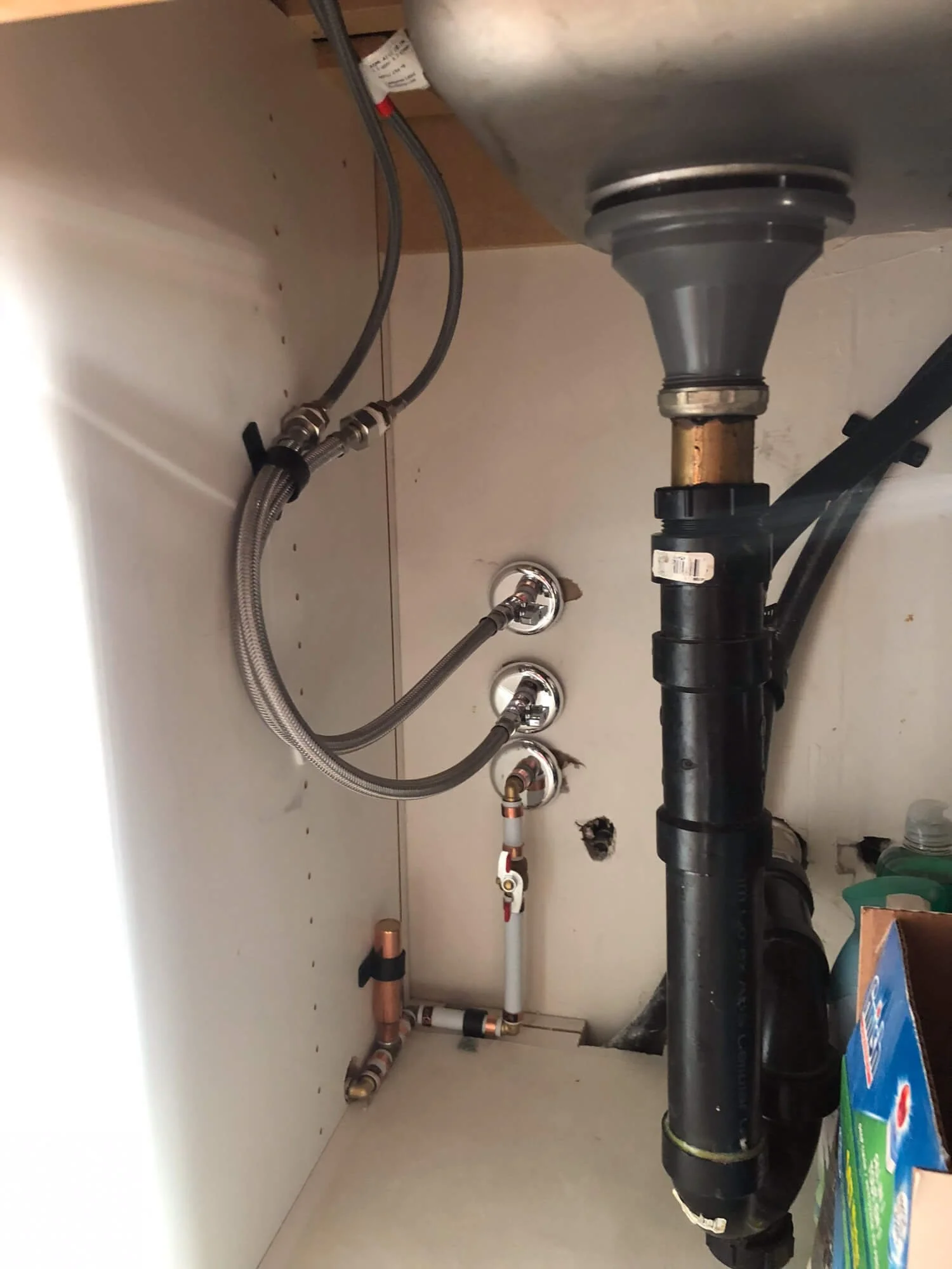 In-progress kitchen sink plumbing update showing PEX pipe installation and updated drainage systems.