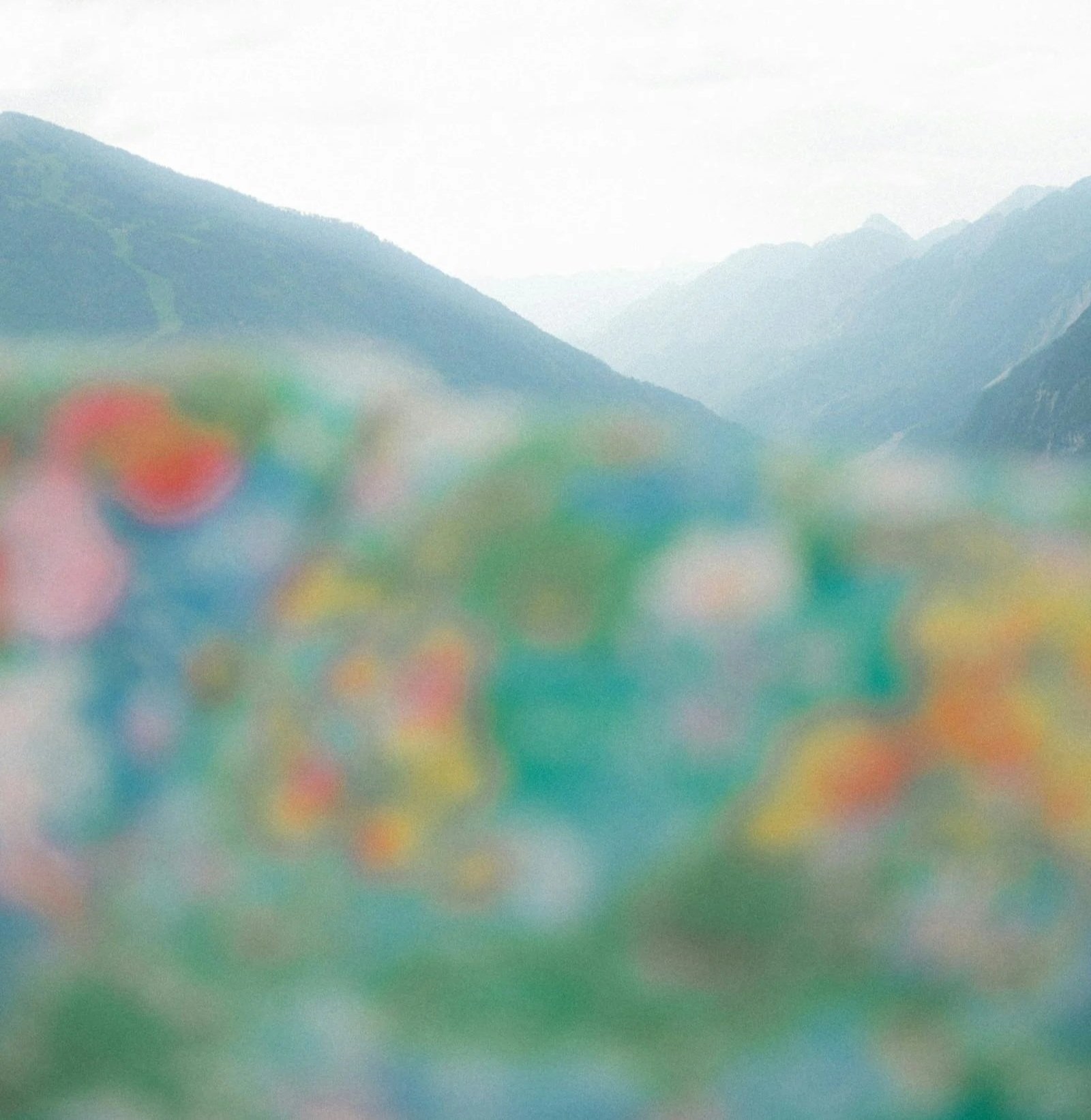 Blurred image of colorful beads with mountains in the background.