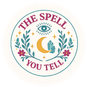 A circular logo with the text "The Spell You Tell" around a crescent moon, stars, and botanical elements in pastel colors.