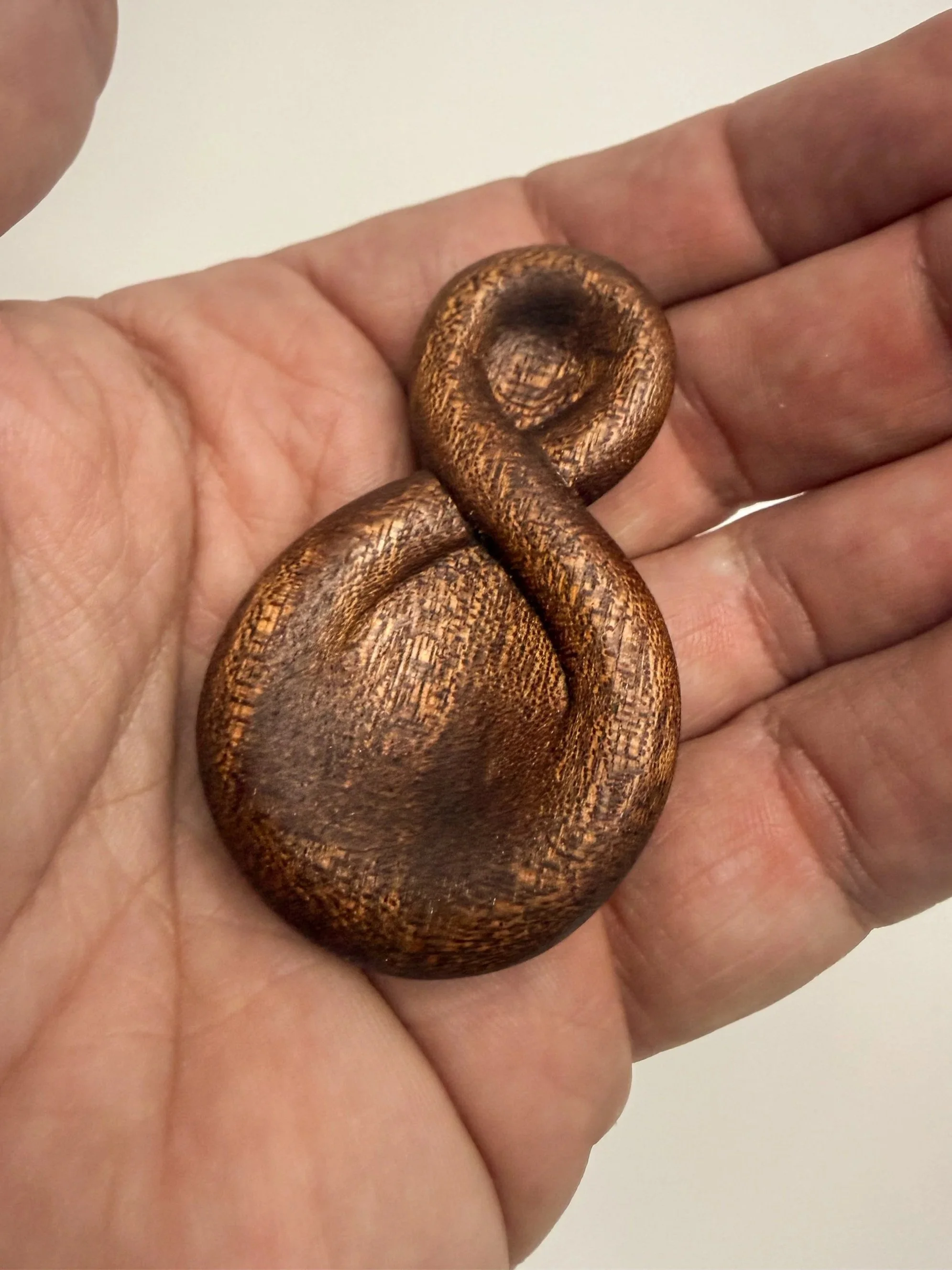 Handheld sculptural wood study titled Continuum held in hand