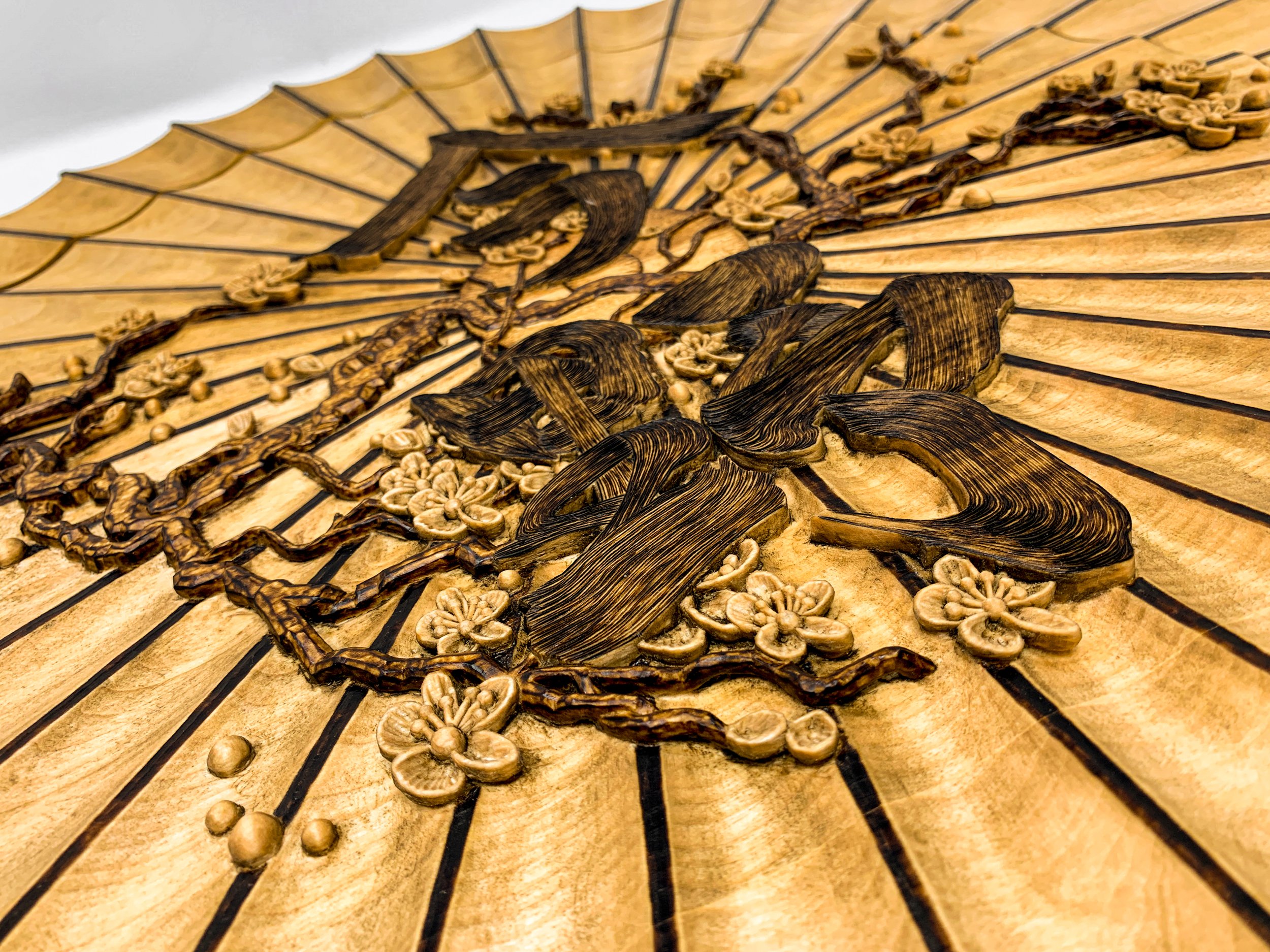 Oblique View of radial carved wood wall sculpture titled Wagasa by Smoke & Ember Studios