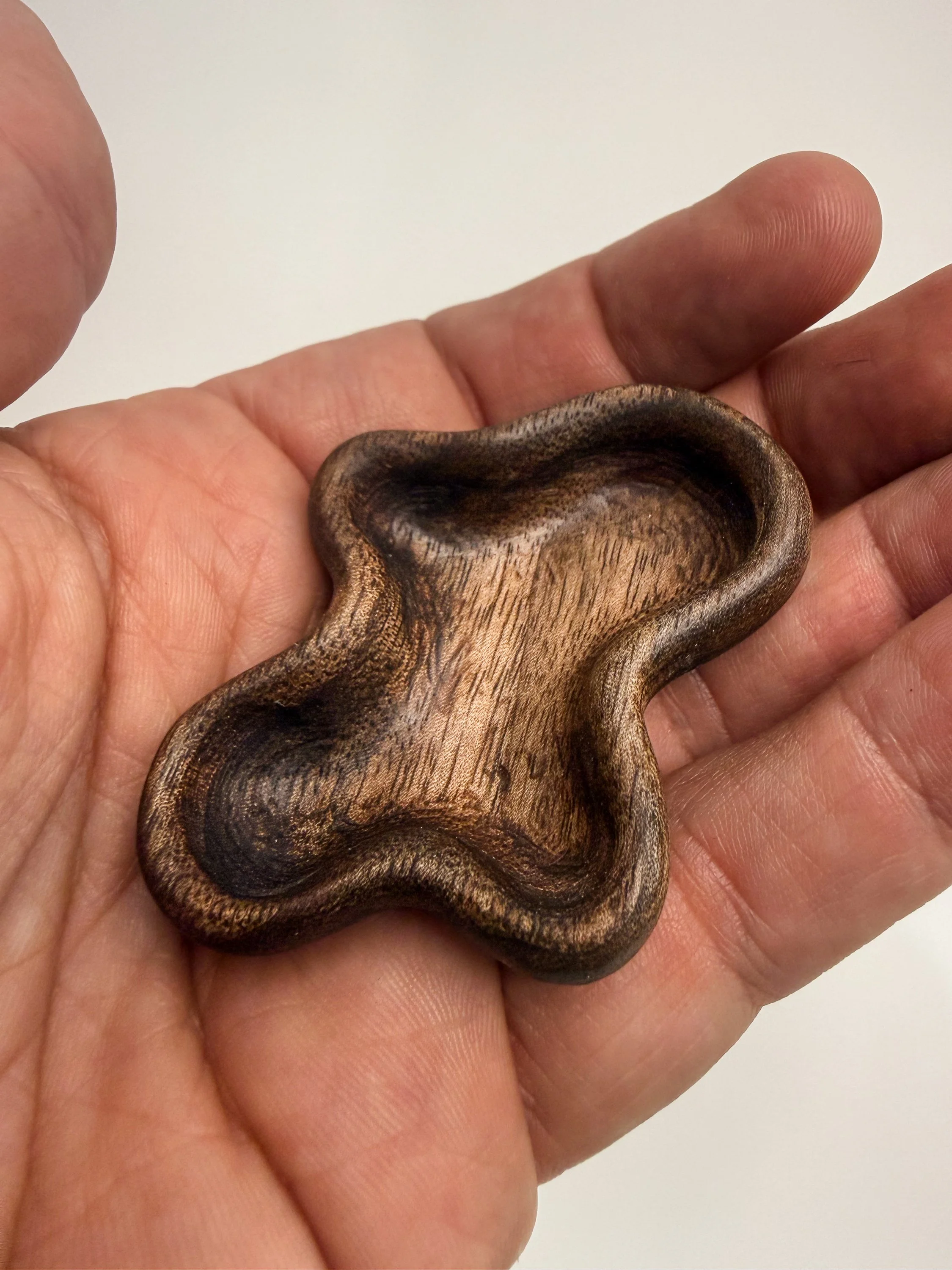 Handheld sculptural wood study titled Flow held in hand