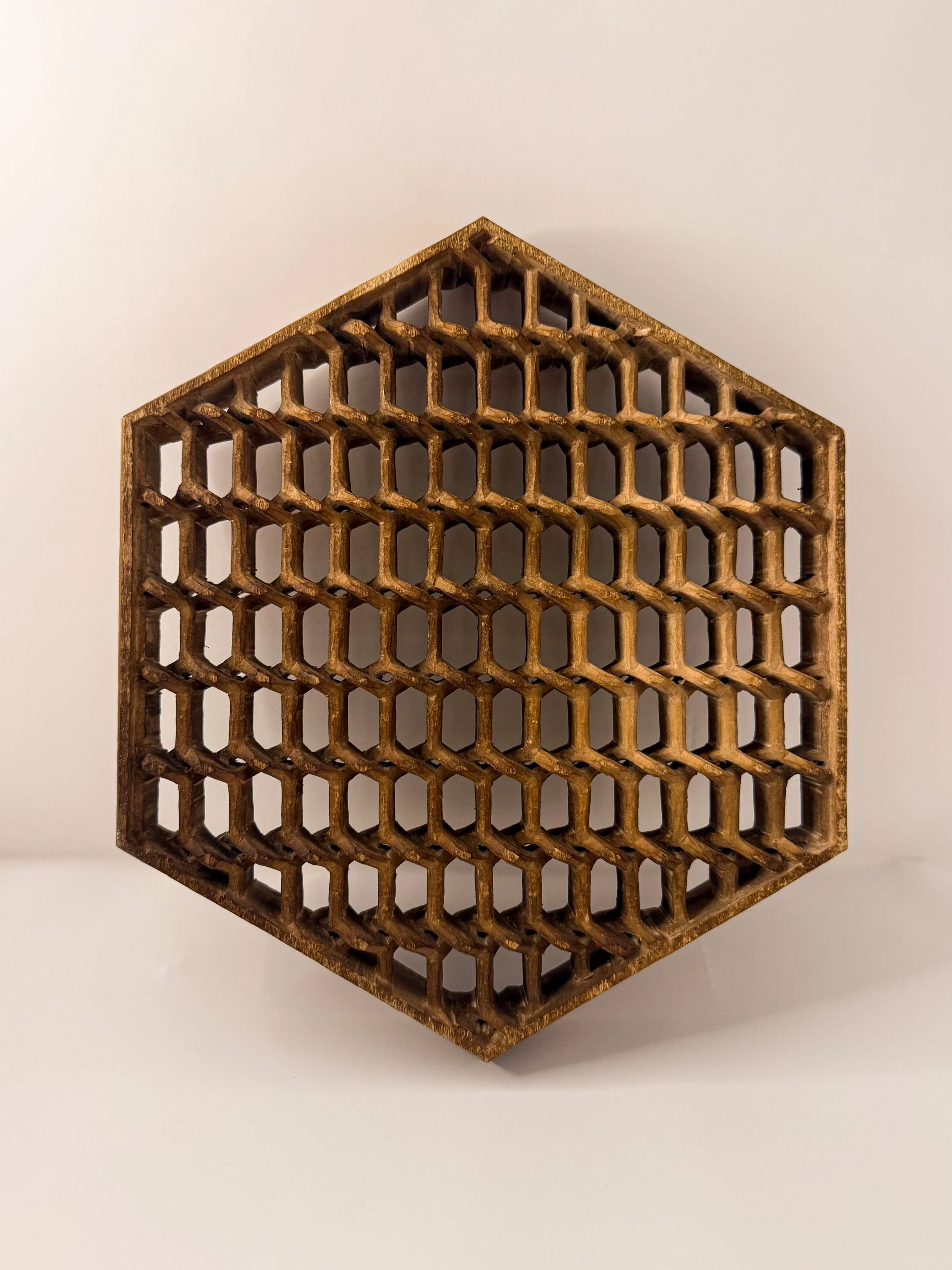 A wooden honeycomb-shaped decorative box with open hexagonal compartments on a white background.