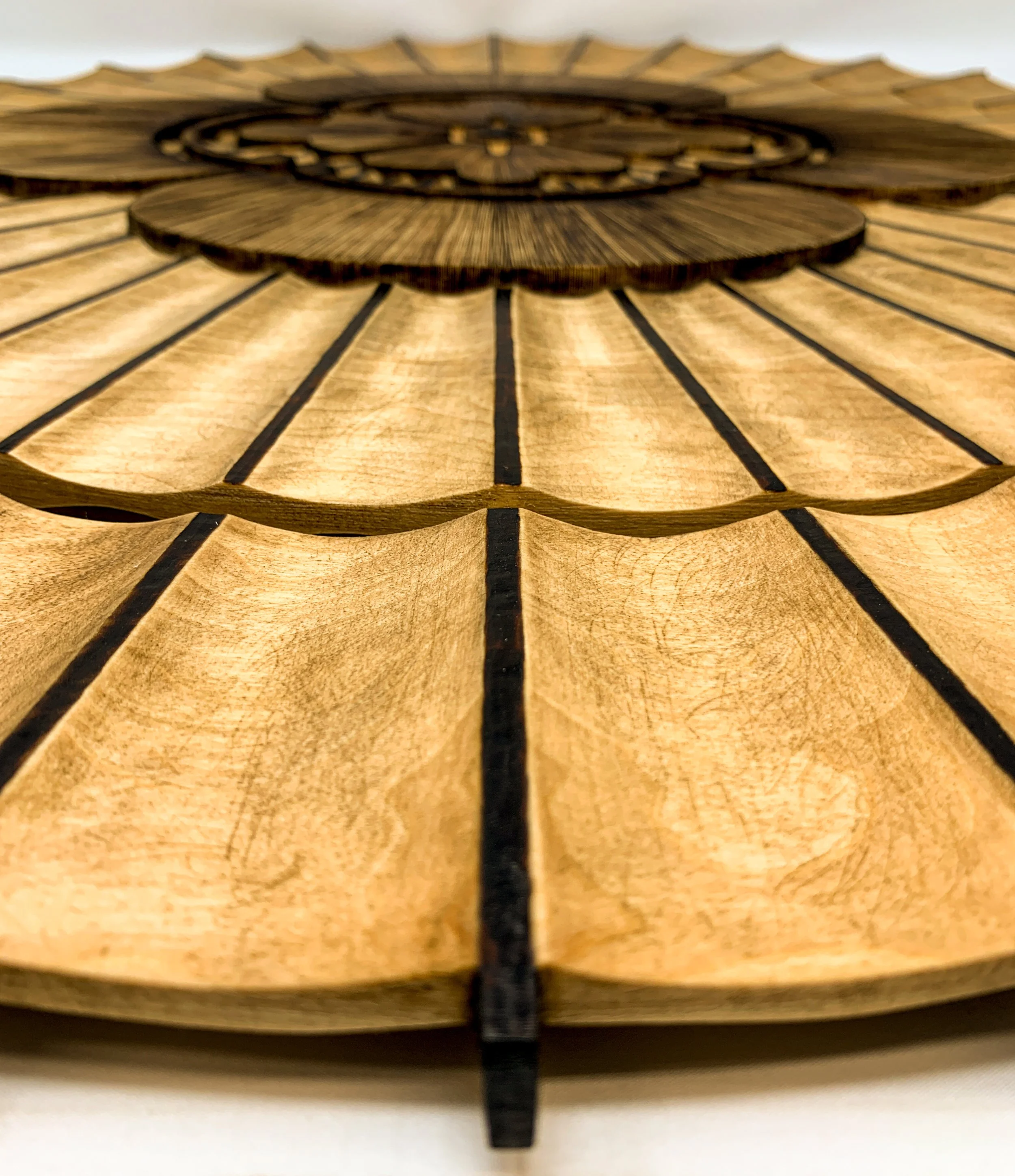 Isometric view of radial carved wood wall sculpture titled Wagasa by Smoke & Ember Studios