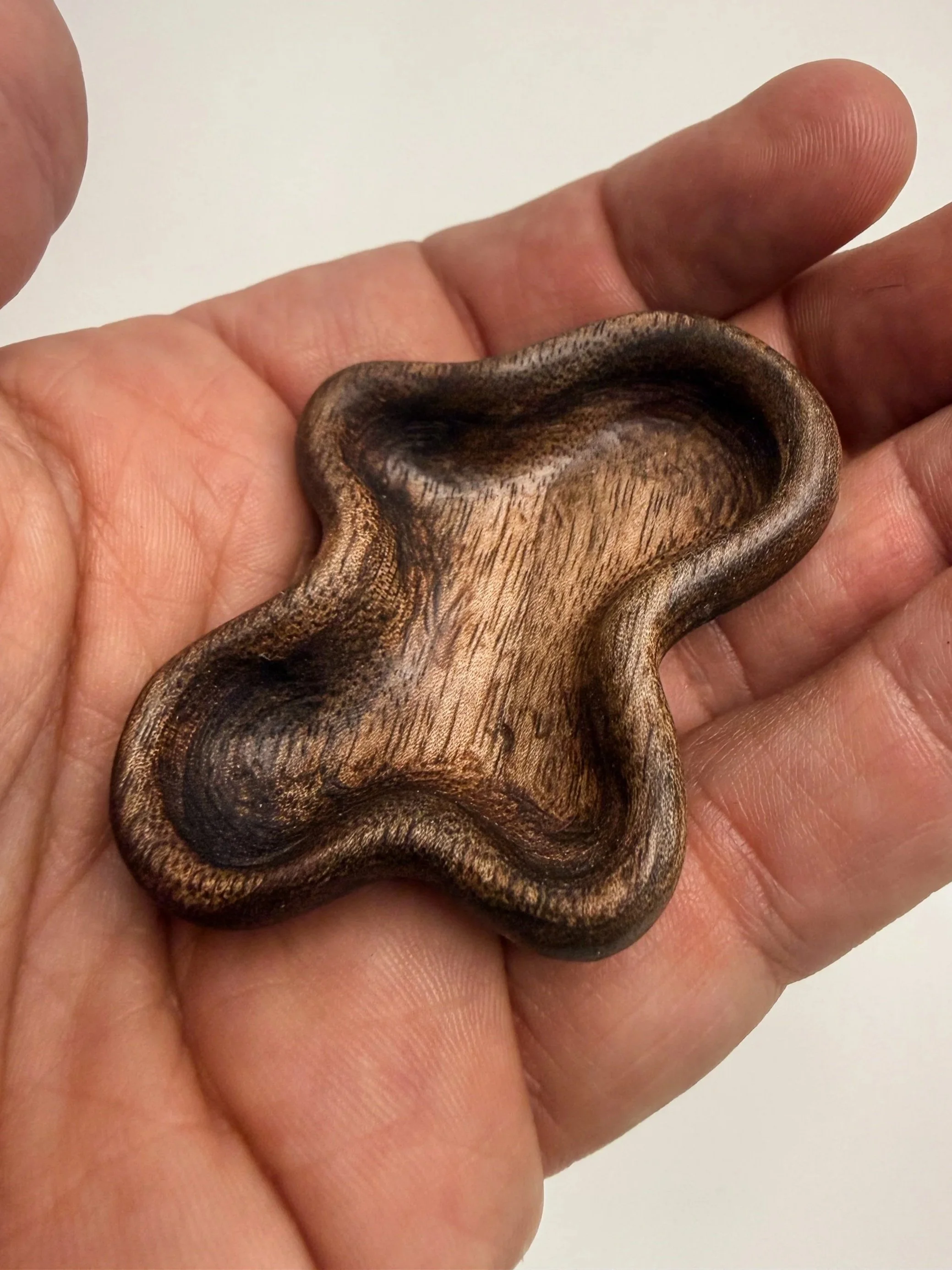 Handheld sculptural wood study titled Flow held in hand