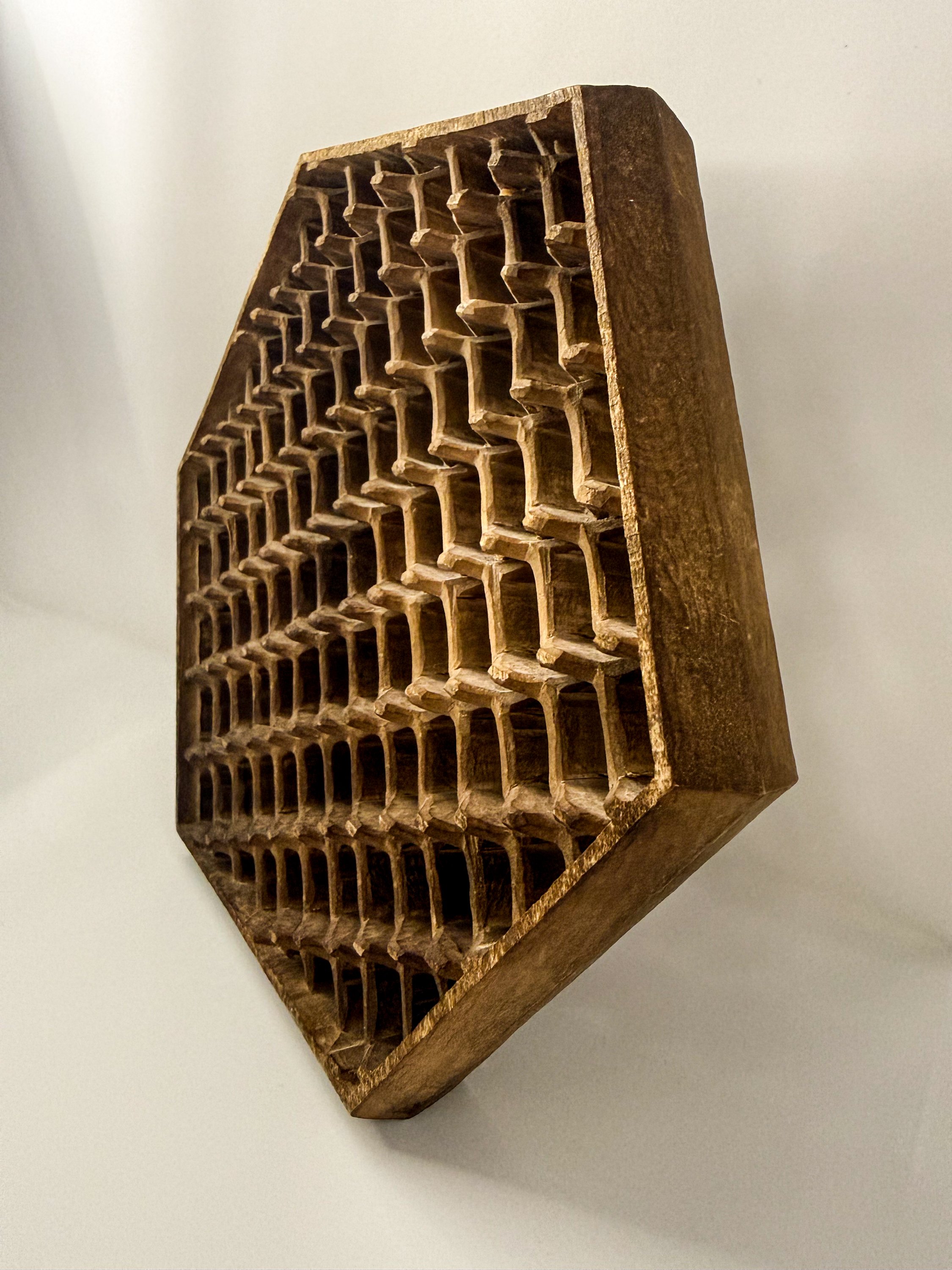 Oblique view of geometric carved wood sculpture titled HEX by Smoke & Ember Studios