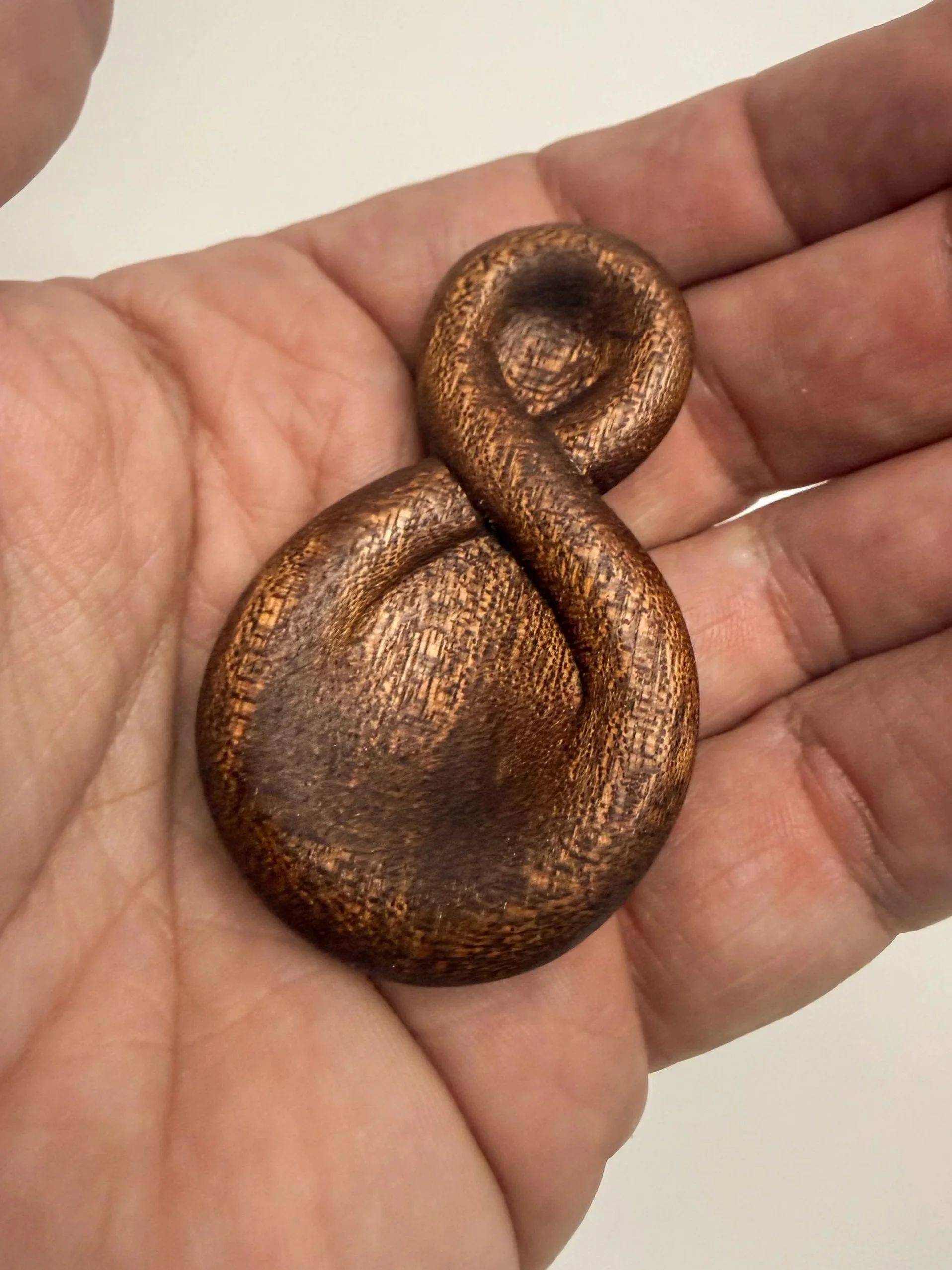 Handheld sculptural wood study titled Continuum held in hand