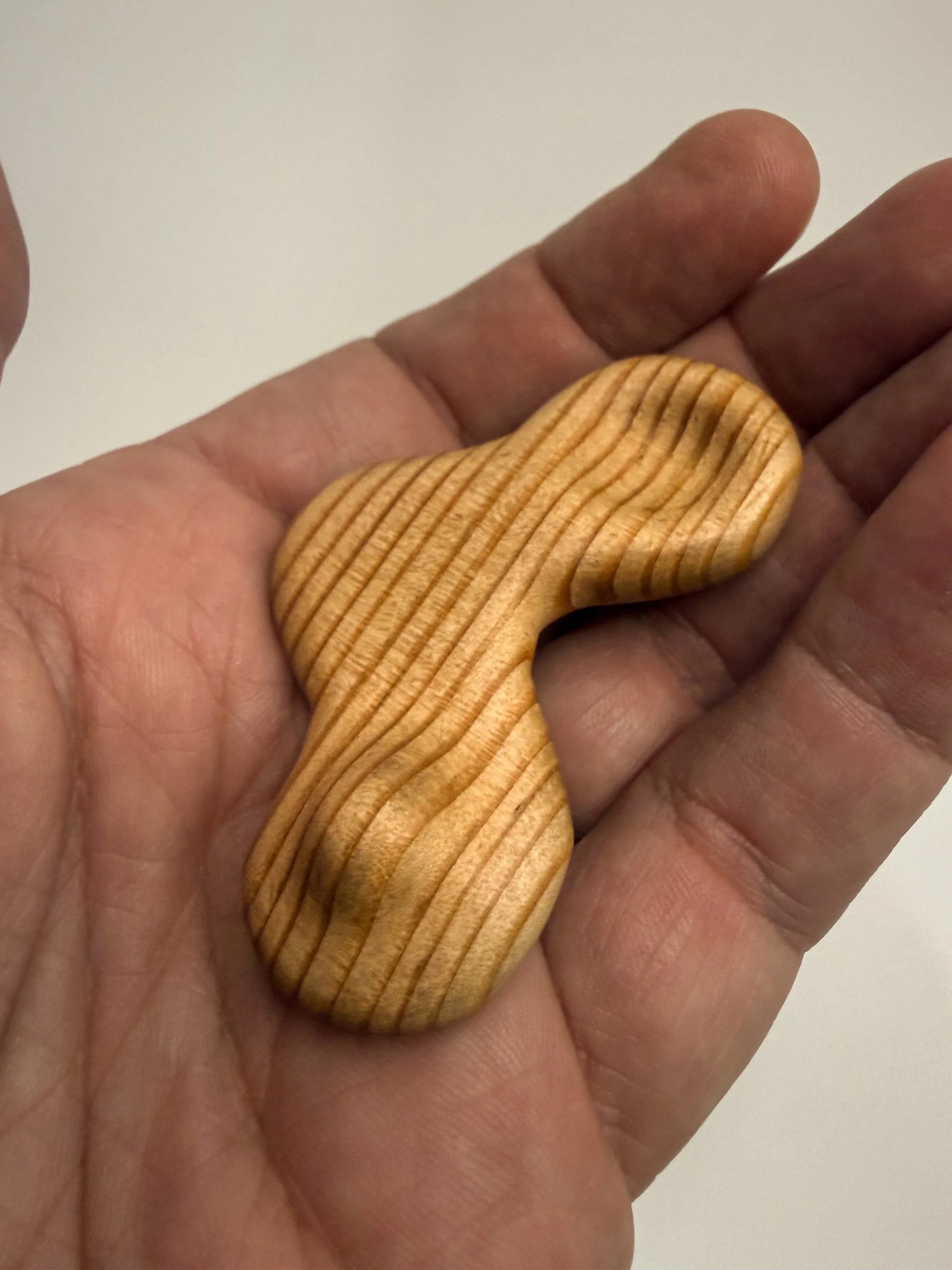 Handheld sculptural wood study titled Drift held in hand