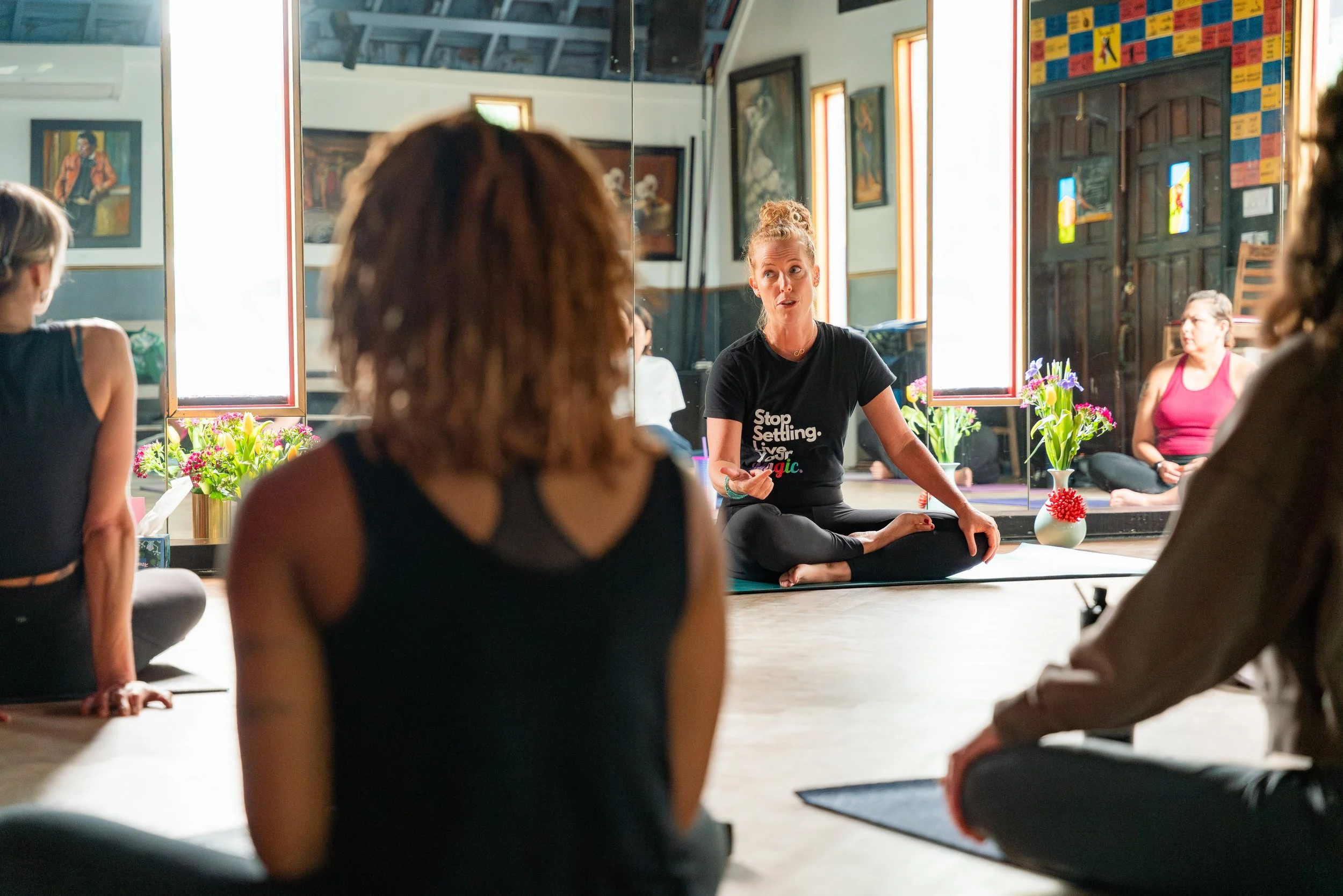 women in fitness event class sitting on yoga mats