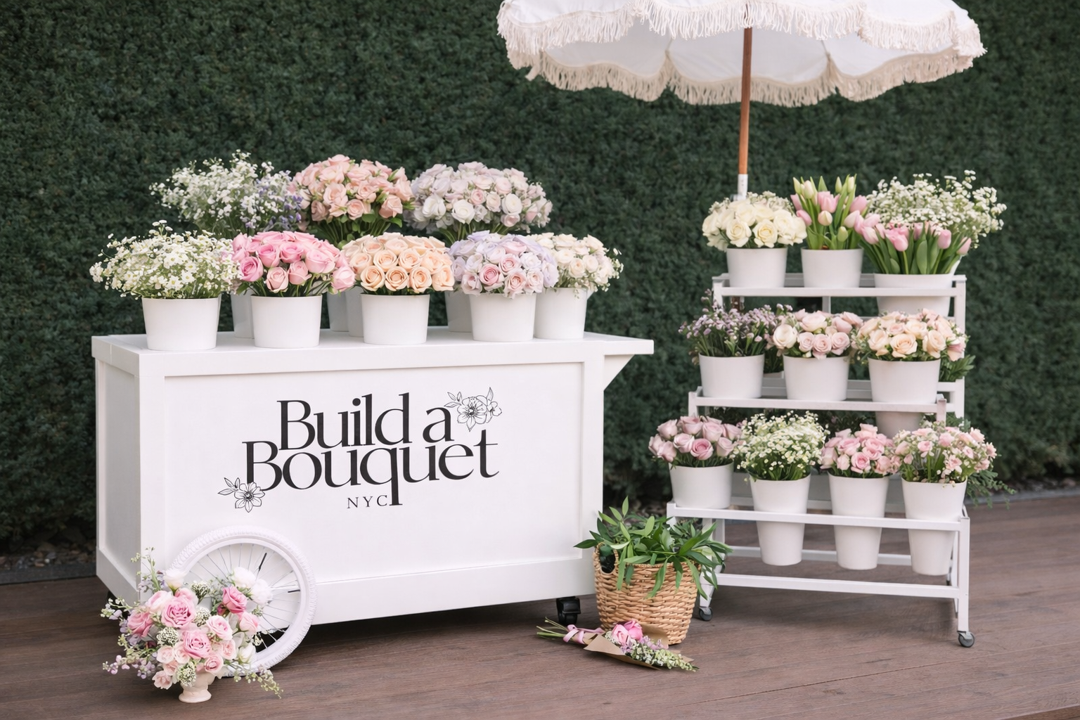 White flower cart and shelves displaying pink and white bouquets and potted flowers at Build a Bouquet NYC shop.