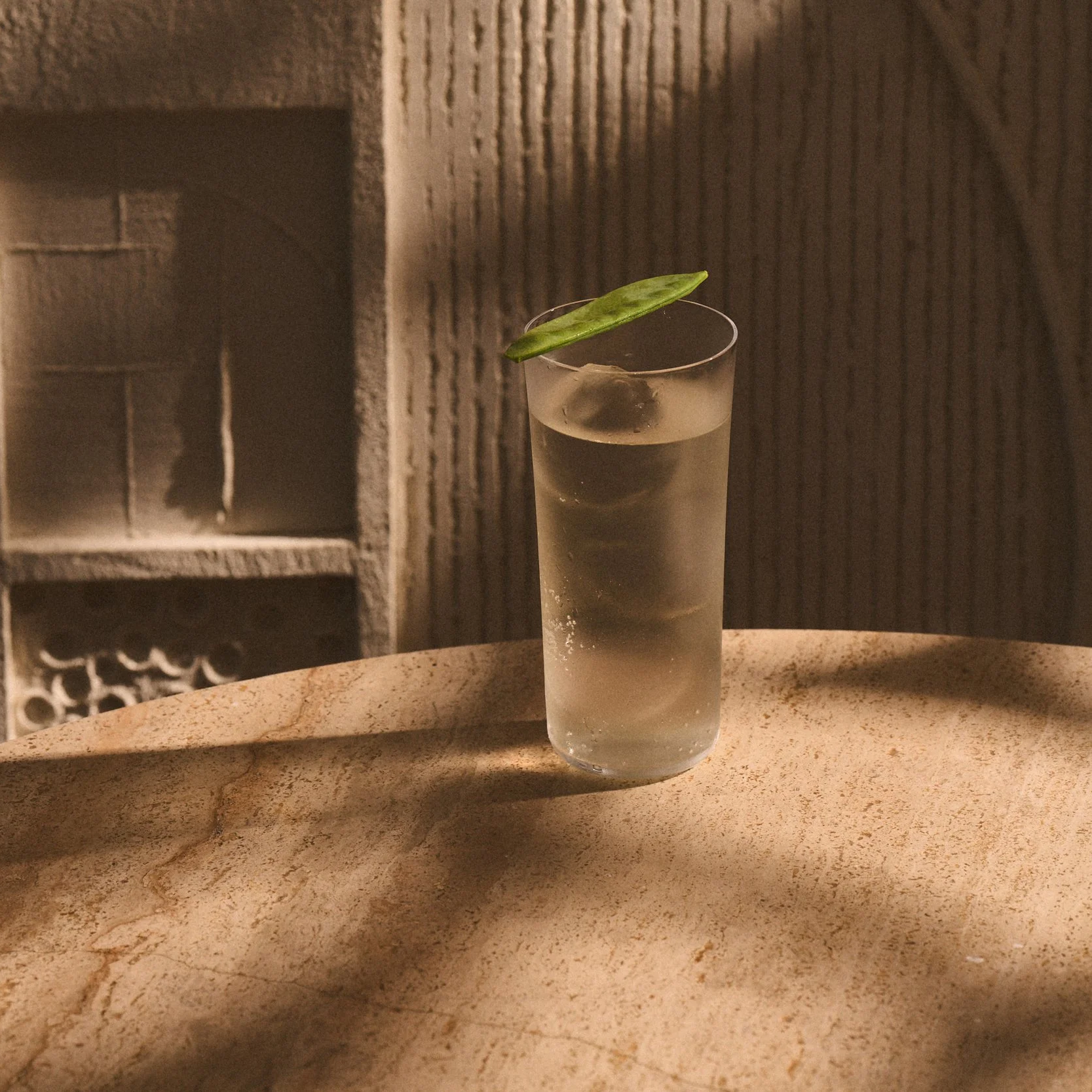 A refreshing cocktail drink with a garnish displayed on a table at AVA Coconut Grove