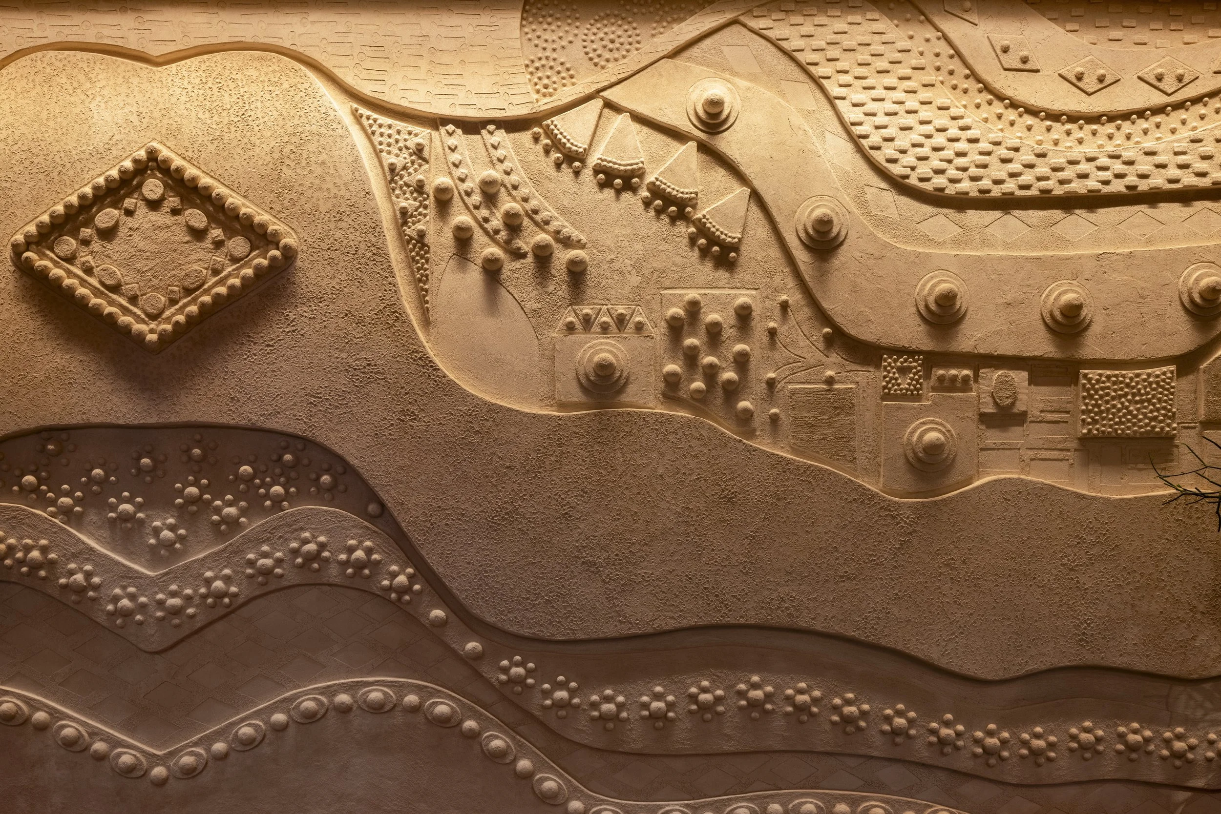 Close-up view of an abstract textured artwork with raised designs and patterns in earthy tones.