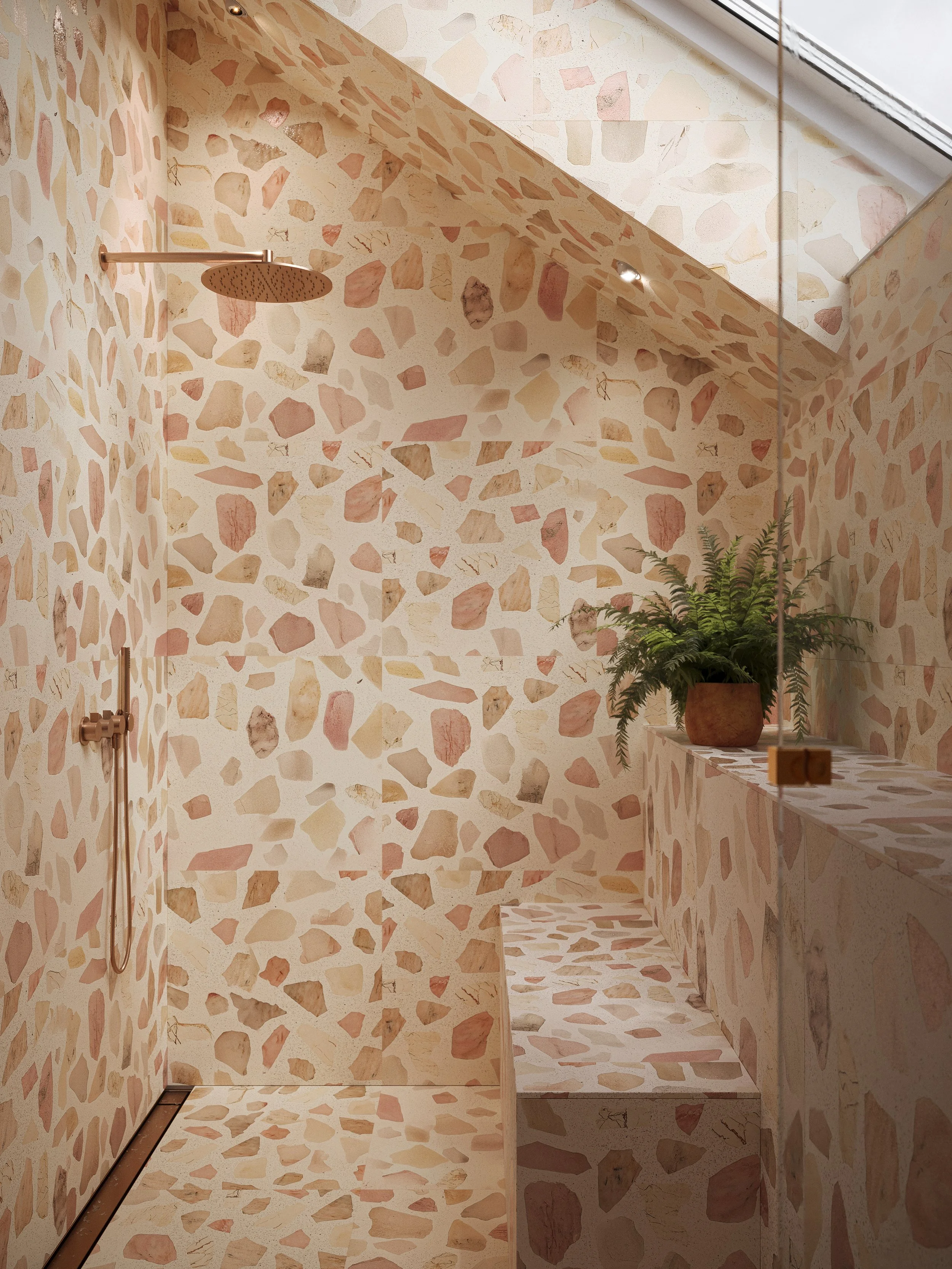 A stylish walk-in shower with terrazzo tiles on the walls, ceiling, and built-in bench, featuring a rain showerhead, a handheld shower, and a skylight for natural light. There is a potted fern on a ledge inside the shower.