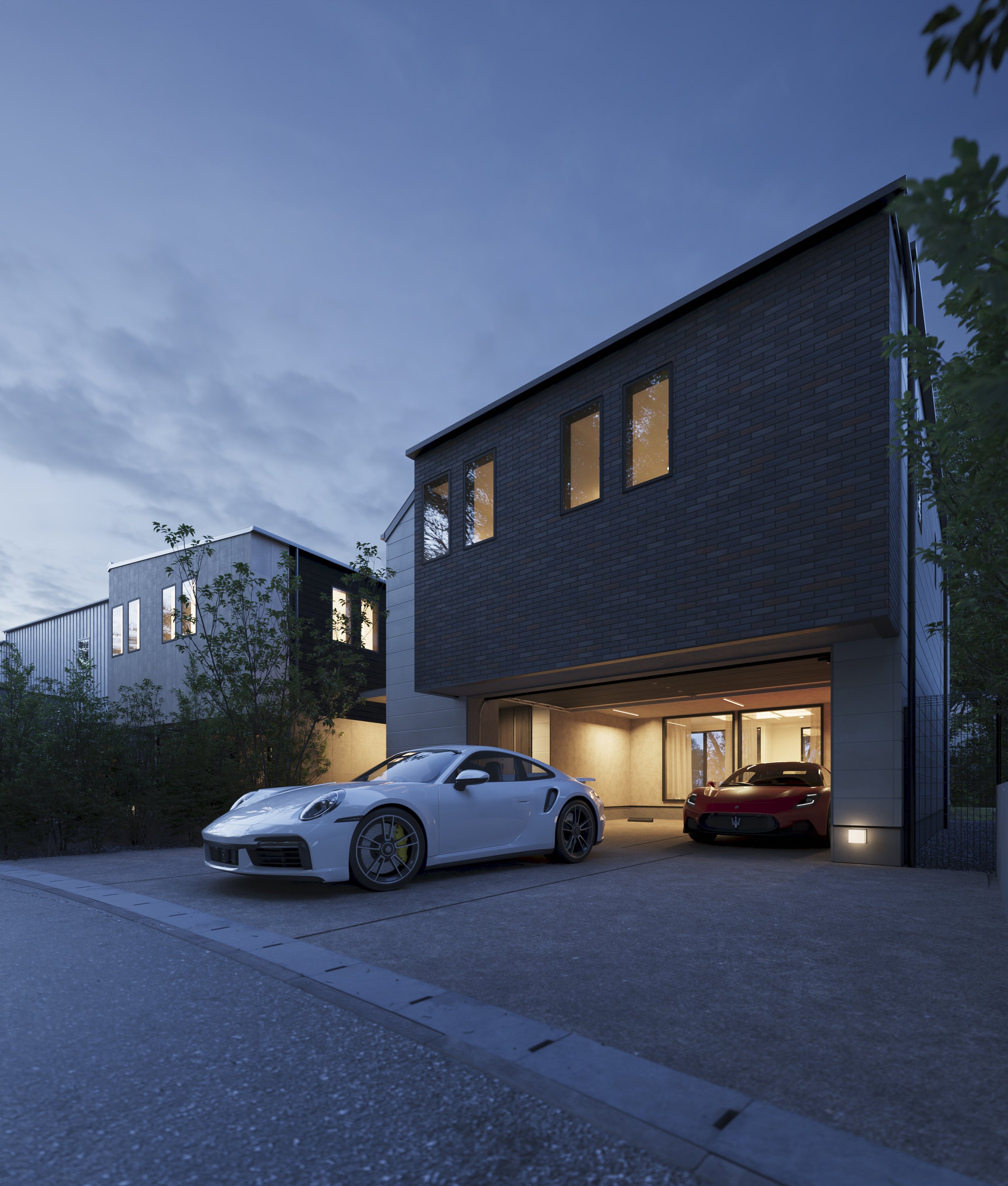 Modern house with illuminated windows and two luxury cars parked in the driveway during evening, trees in the foreground.