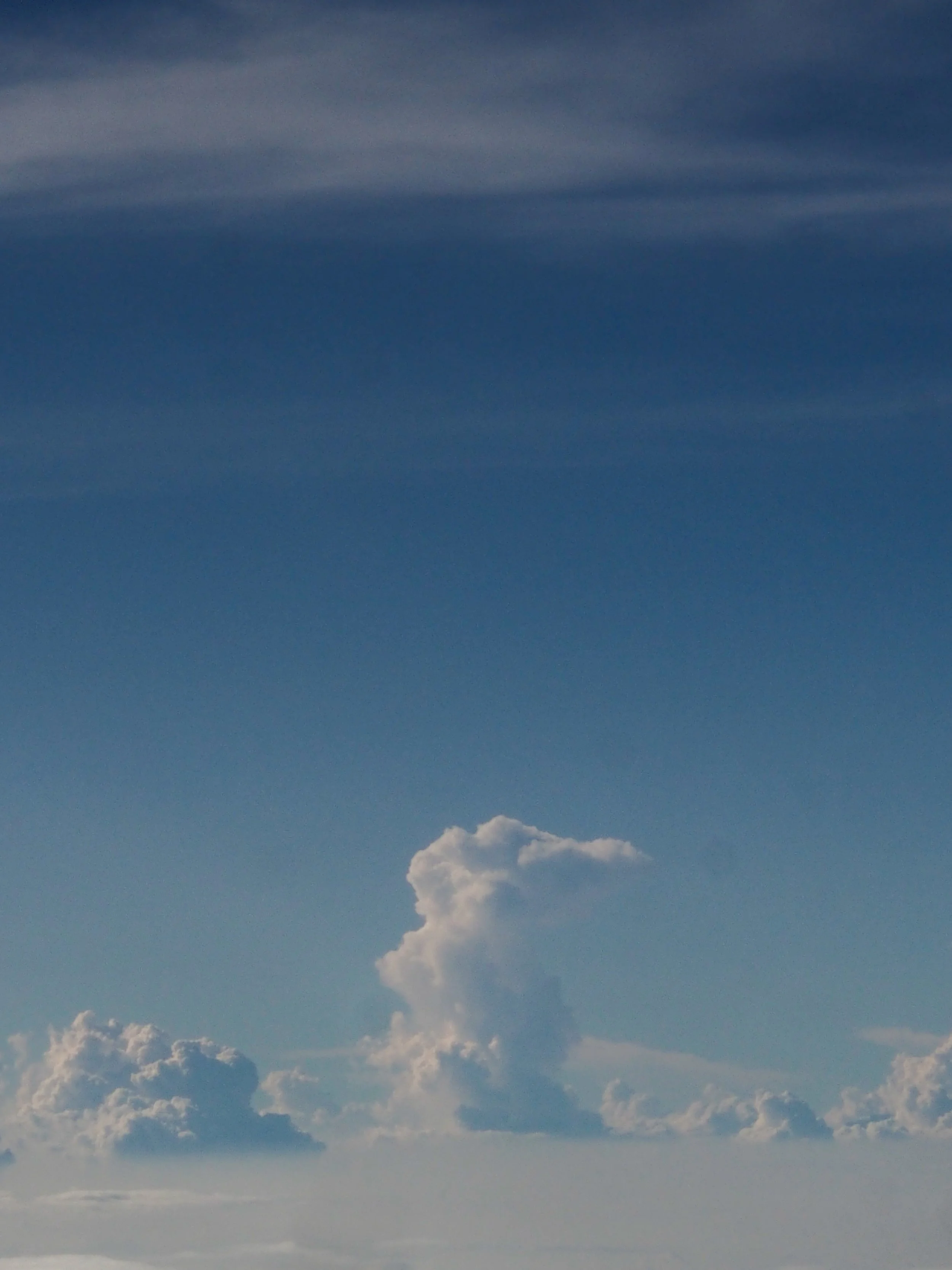 Sky with various clouds, including a large, fluffy cloud with a towering shape.