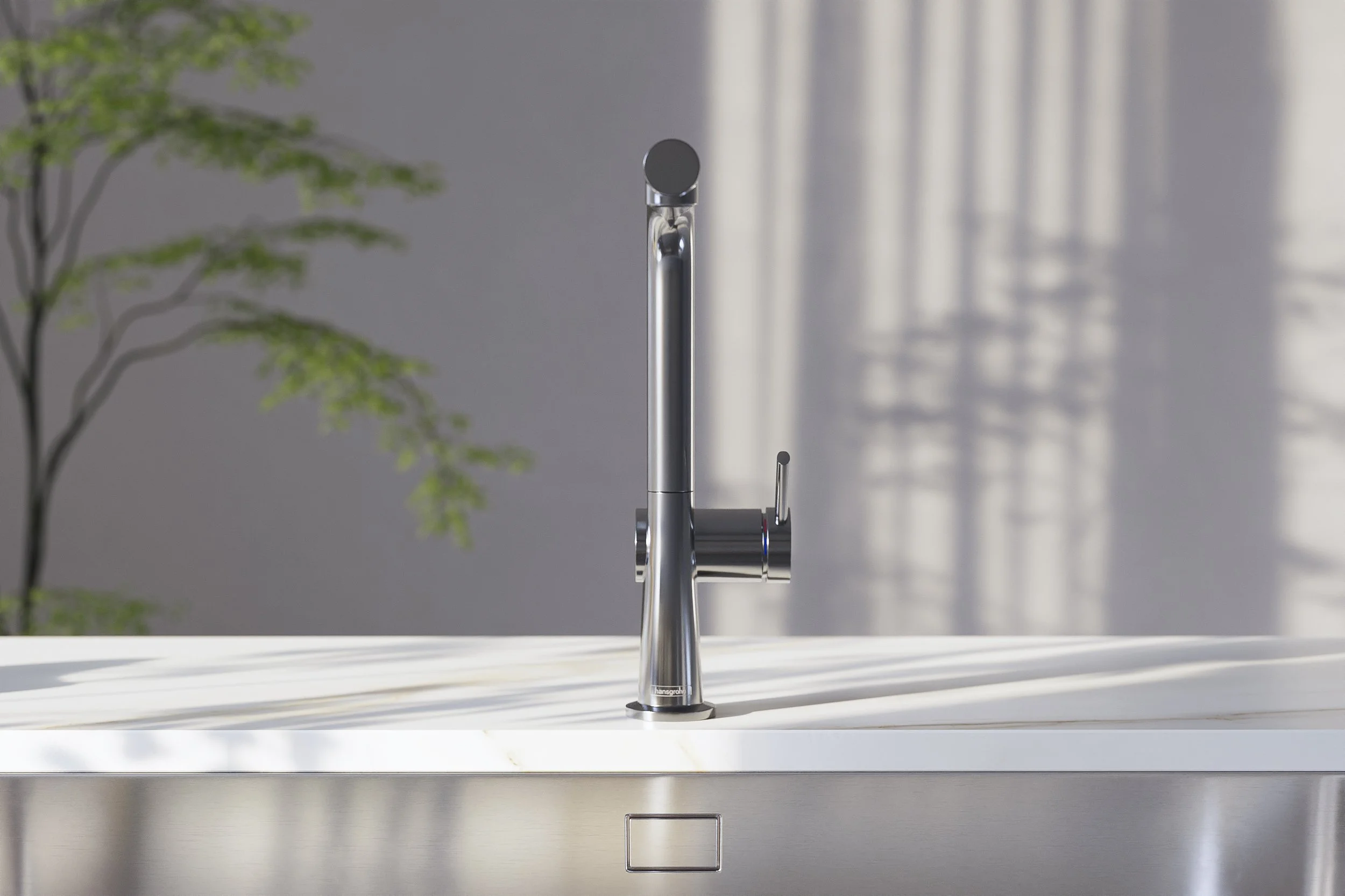 Modern kitchen faucet mounted on a white countertop with a blurred background of a gray wall and a plant.
