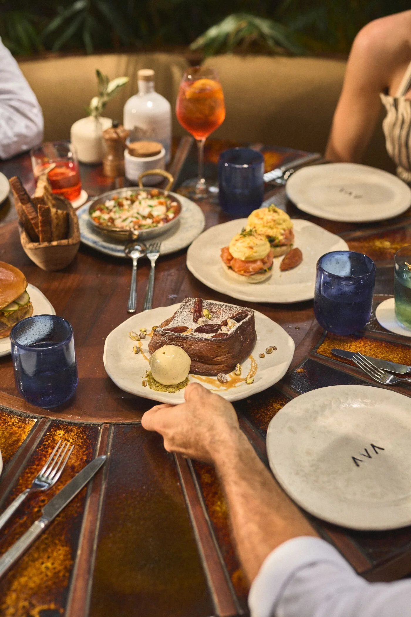 AVA Winter Park brunch menu items such as the french toast, eggs shakshuka, eggs benedict on a table.