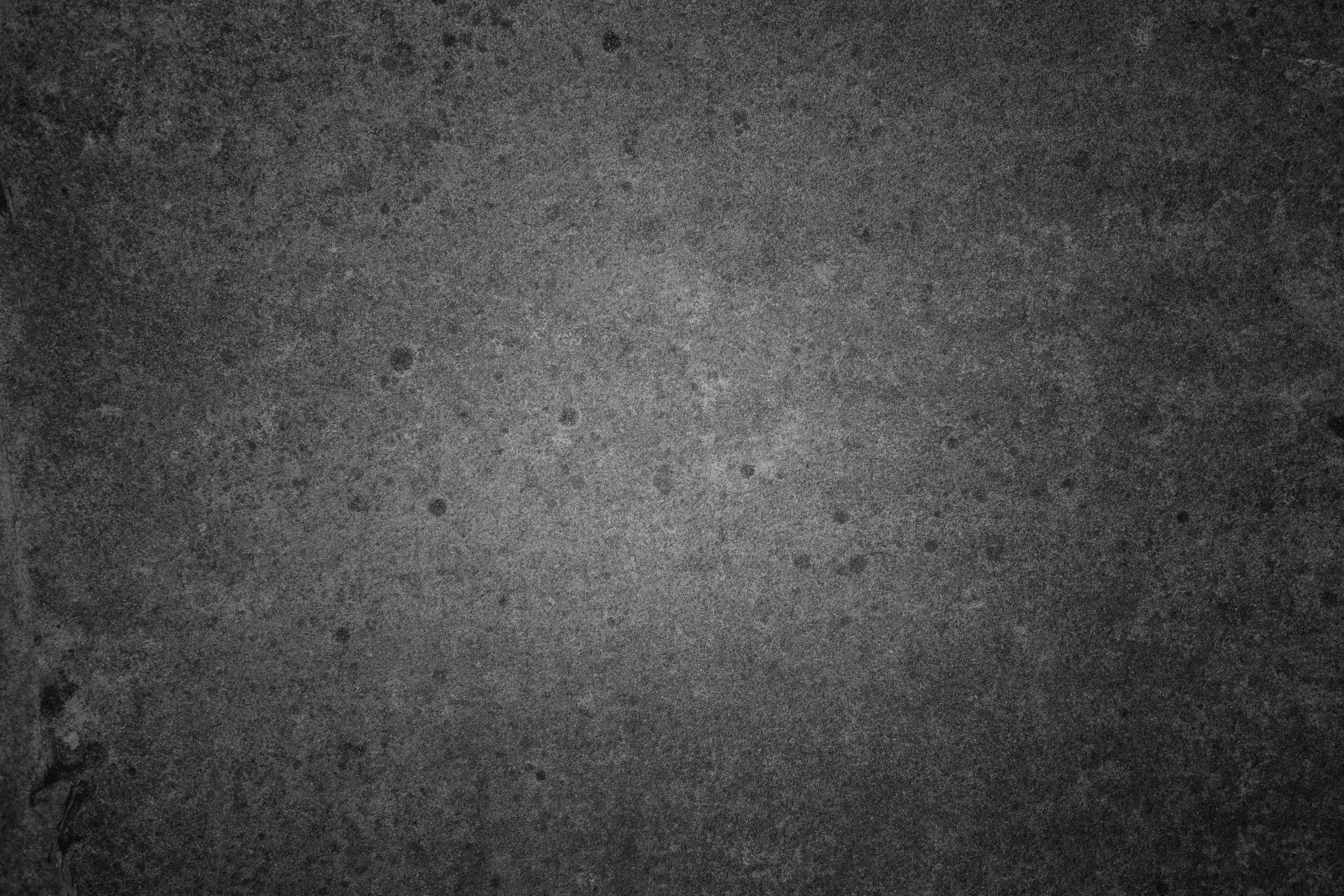 Close-up of a dark gray textured surface, possibly concrete or asphalt.