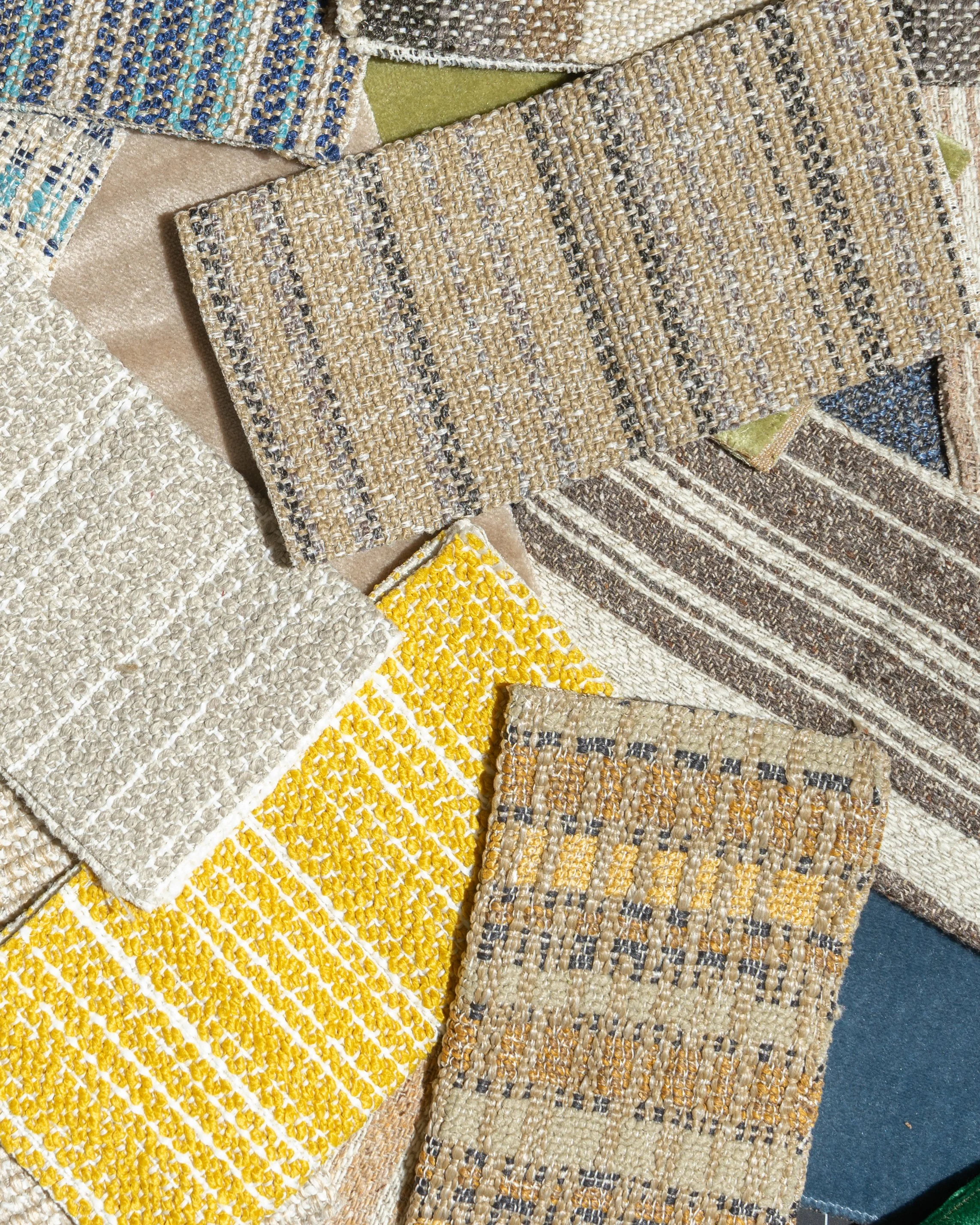Une collection de divers échantillons de tissus tissés et texturés, aux couleurs et motifs variés — notamment jaune, beige, gris, bleu et vert — disposés de manière superposée.