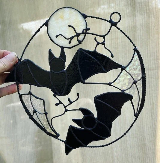 Halloween hanging piece featuring two black bats and a white full moon, inside a circular wire frame.