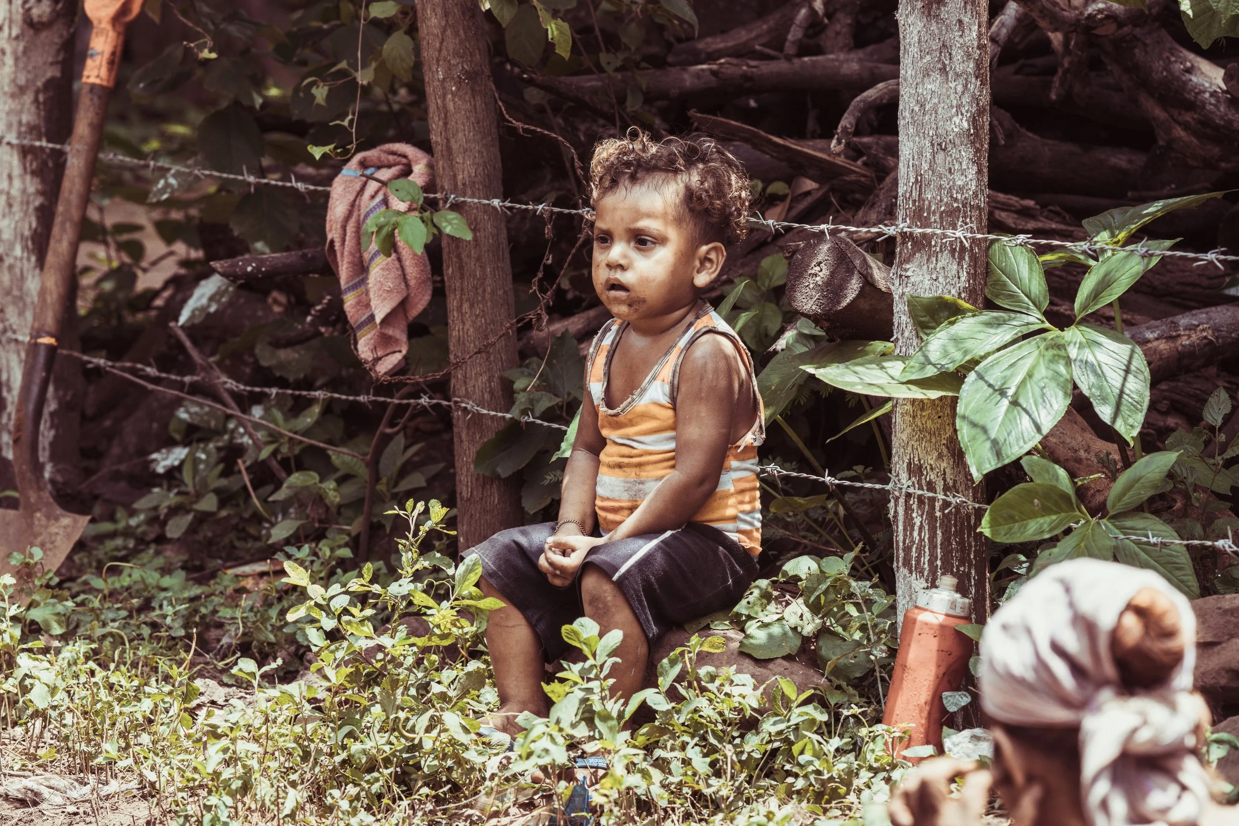 A young child observing plumbing work being done during a mission trip in Nicaragua.