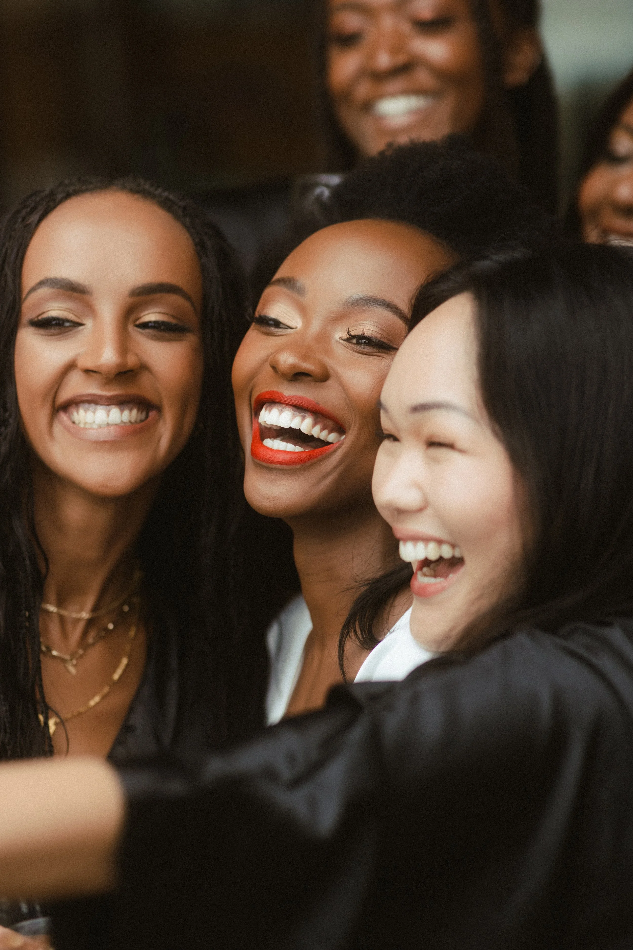 Group of women taking a close-up selfie together, smiling and laughing.