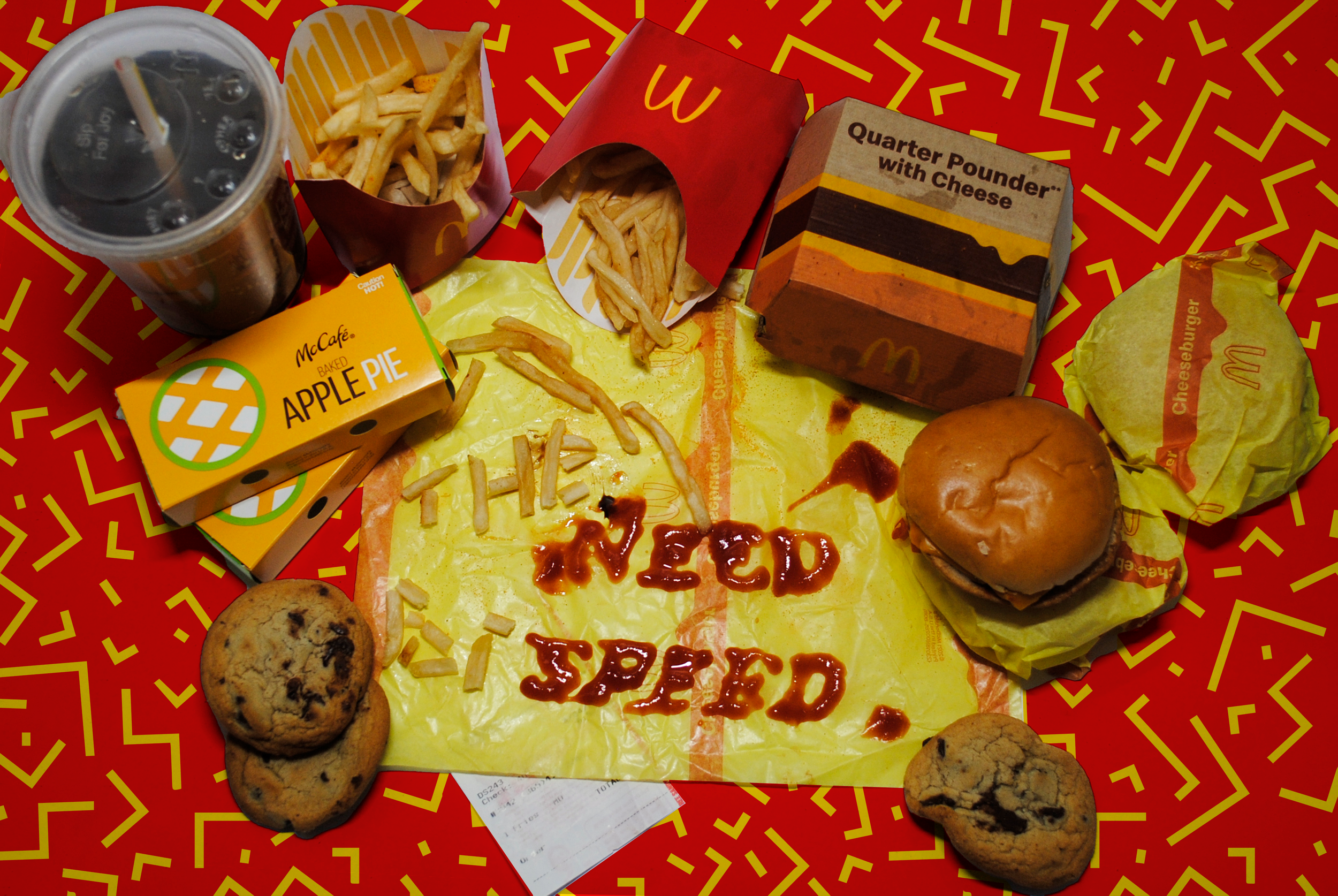 A McDonald's meal with French fries, a cheeseburger, an apple pie, chocolate chip cookies, a large soda, and empty fries container with ketchup spelling 'THINK NEEDED'.