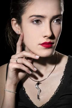 Maquillage léger avec bijoux, lèvres rouges intenses et teint lumineux.