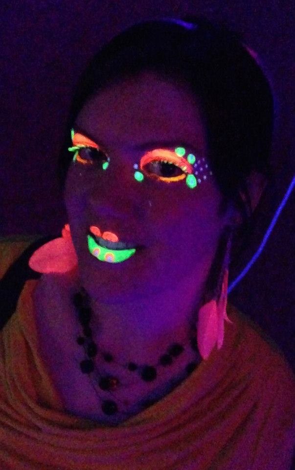 Maquillage yeux UV fluo sous lumière noire, regard intense et précis.
