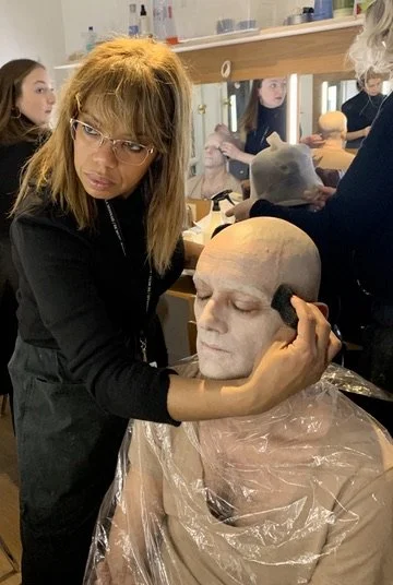 Maquillage théâtre effet faux crâne, rendu marqué sous projecteurs et scène.