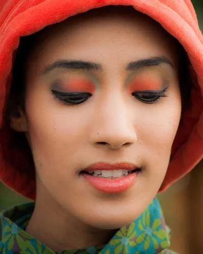 Maquillage orange et vert, look créatif avec contrastes marqués et lumineux.