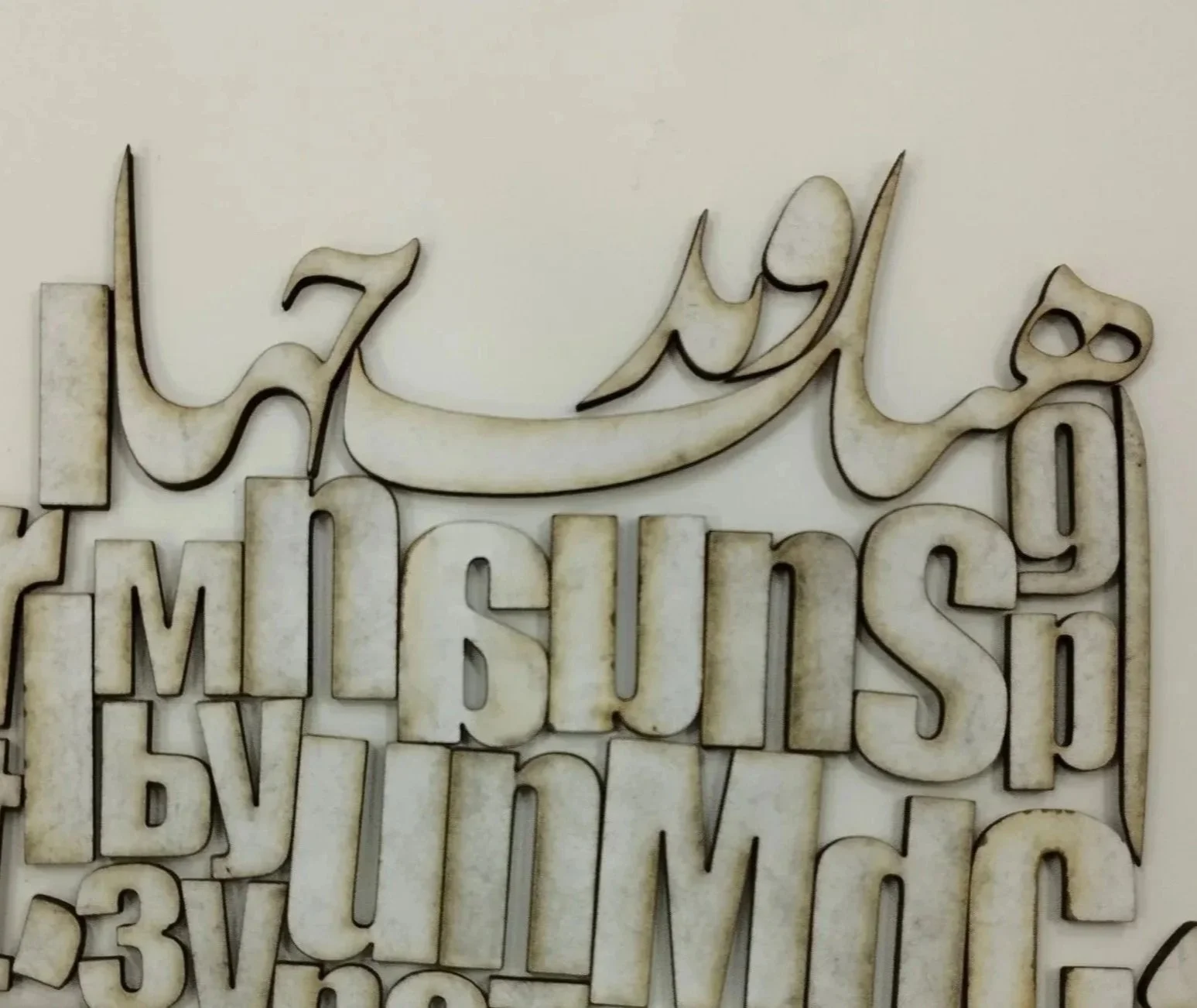 Decorative wall art with Arabic calligraphy and English ed text, reading 'In the name of Allah, Mulsim's by faith'
