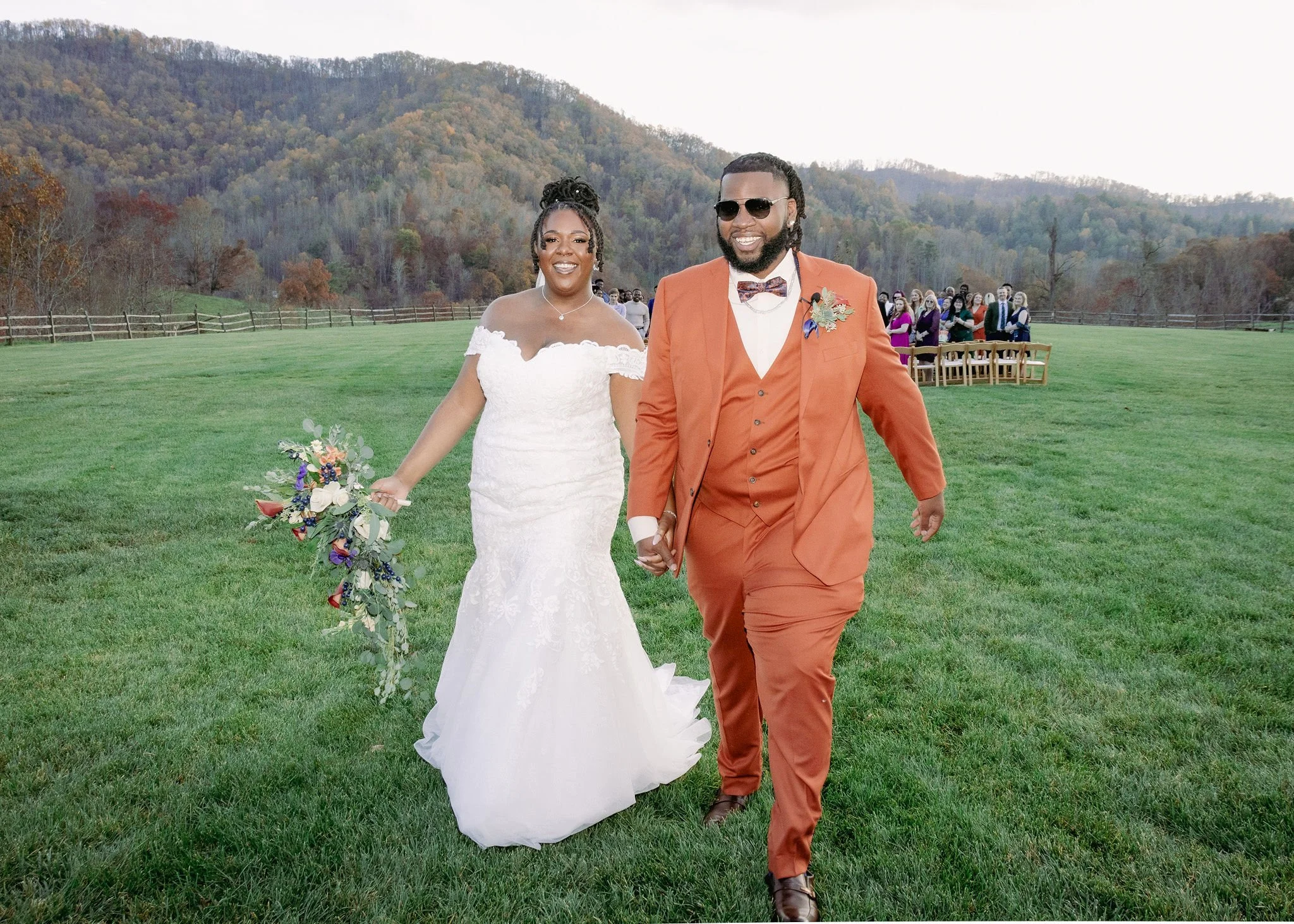 A modern house on a hillside with snow-capped mountains in the background.