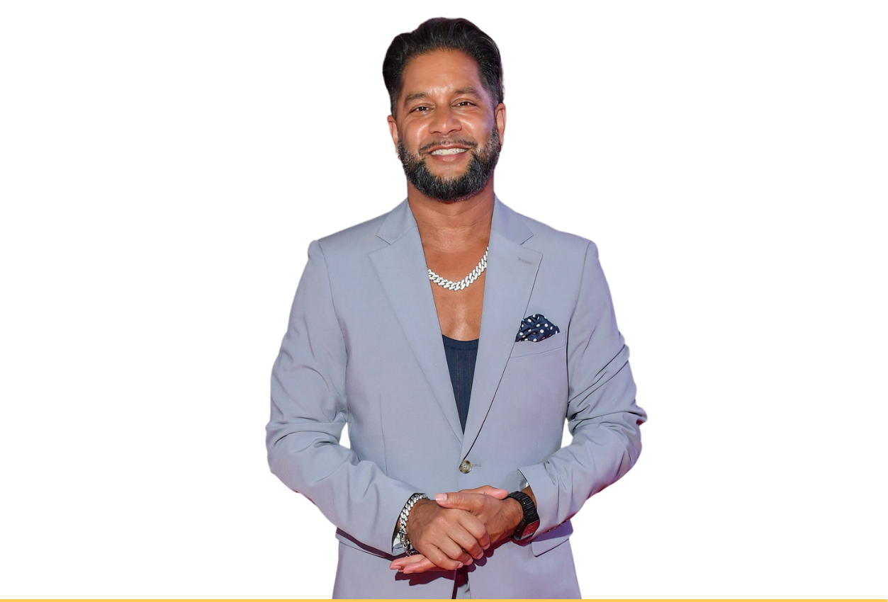 Devo Brown standing in a light grey blazer against a purple background