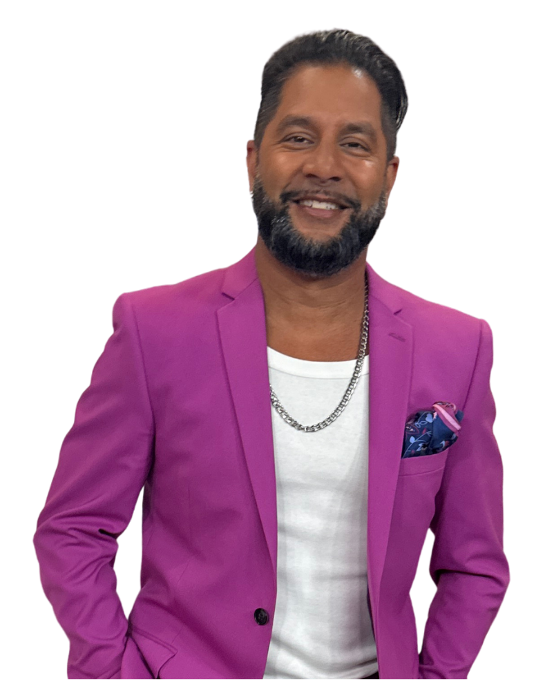 Devo Brown smiling in a magenta blazer for booking and contact section