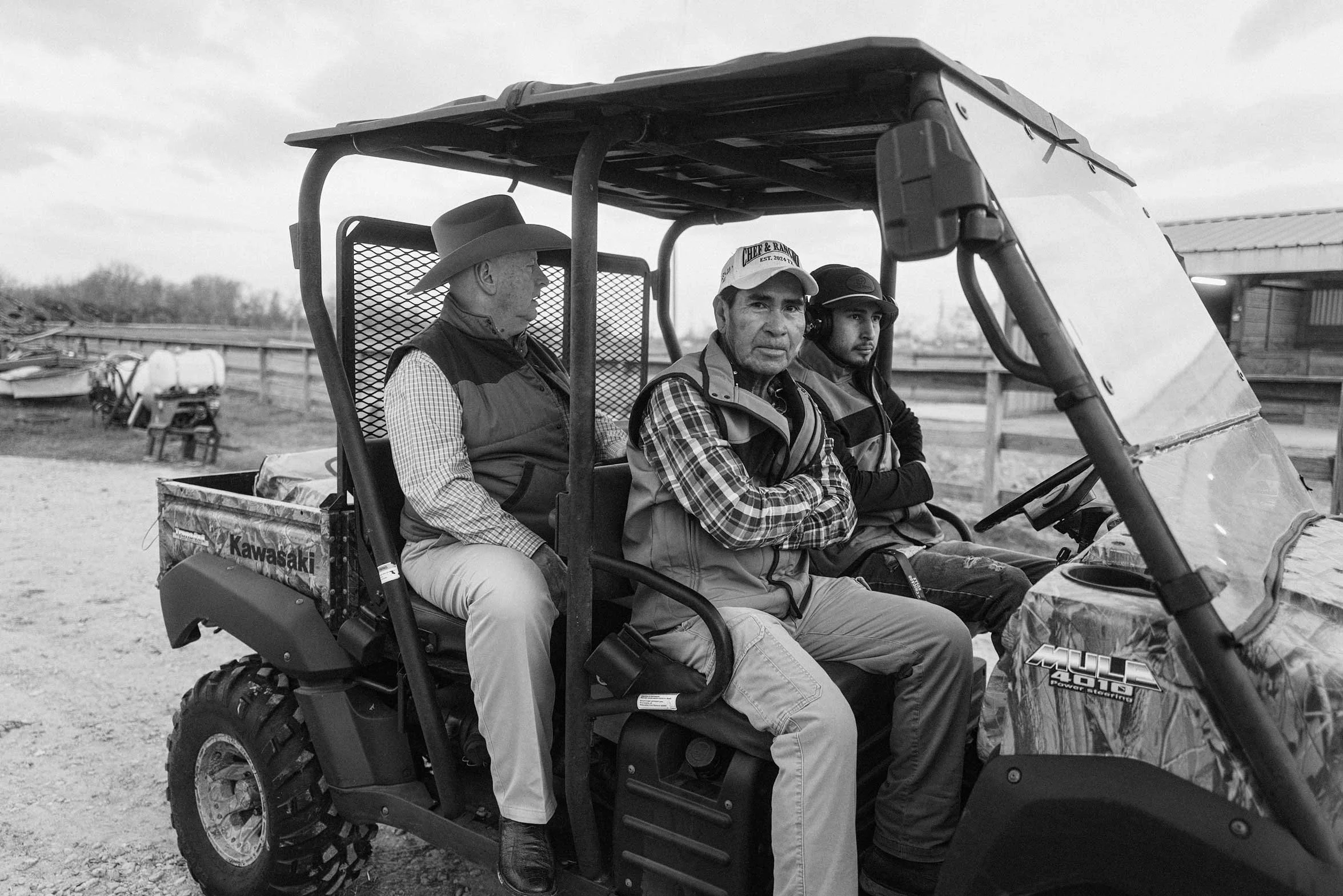 group of people riding in a utility vehicle on a ranch